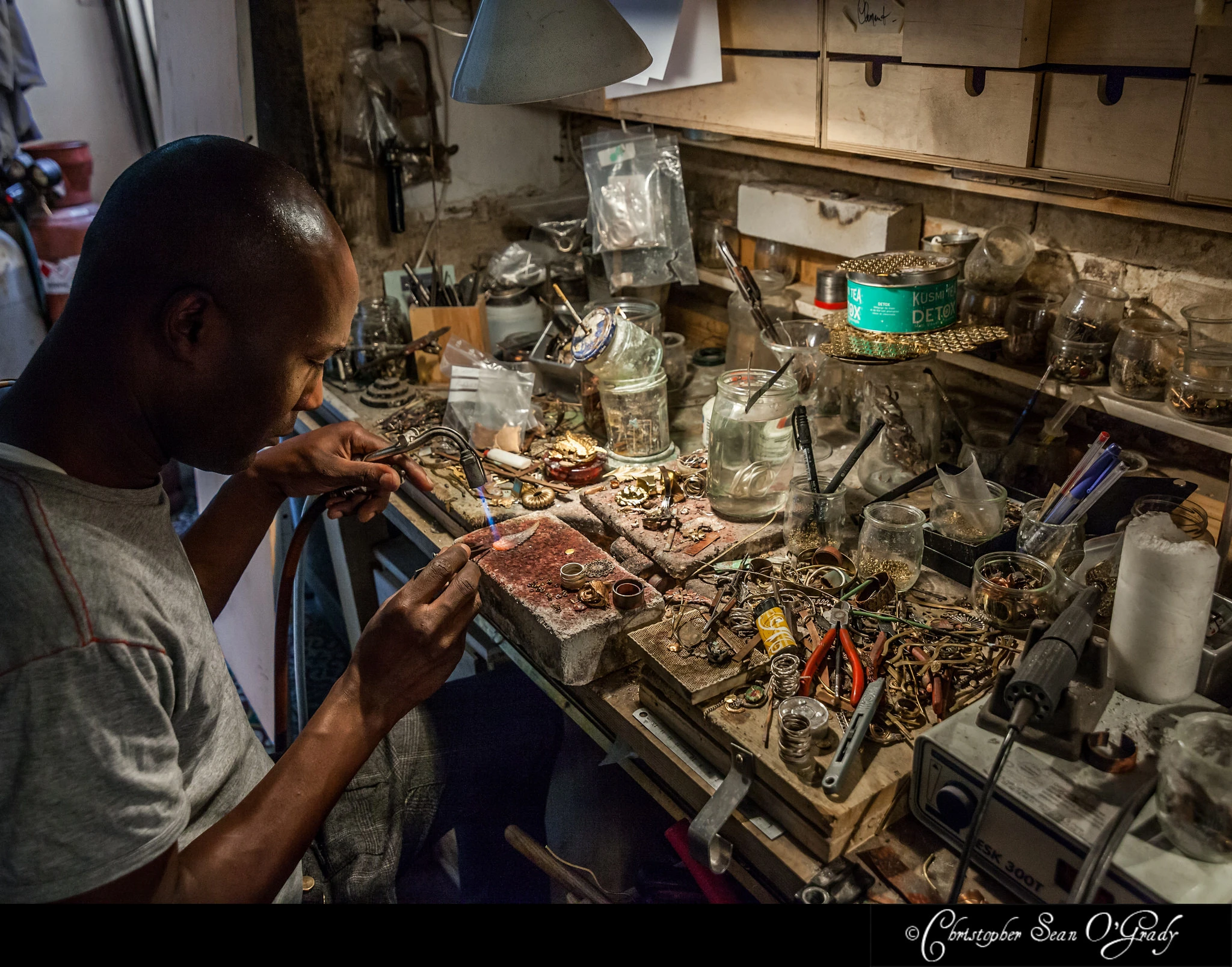 Artisan soldering with torch at jewellery bench — Lotta Djossou Paris lifestyle photography