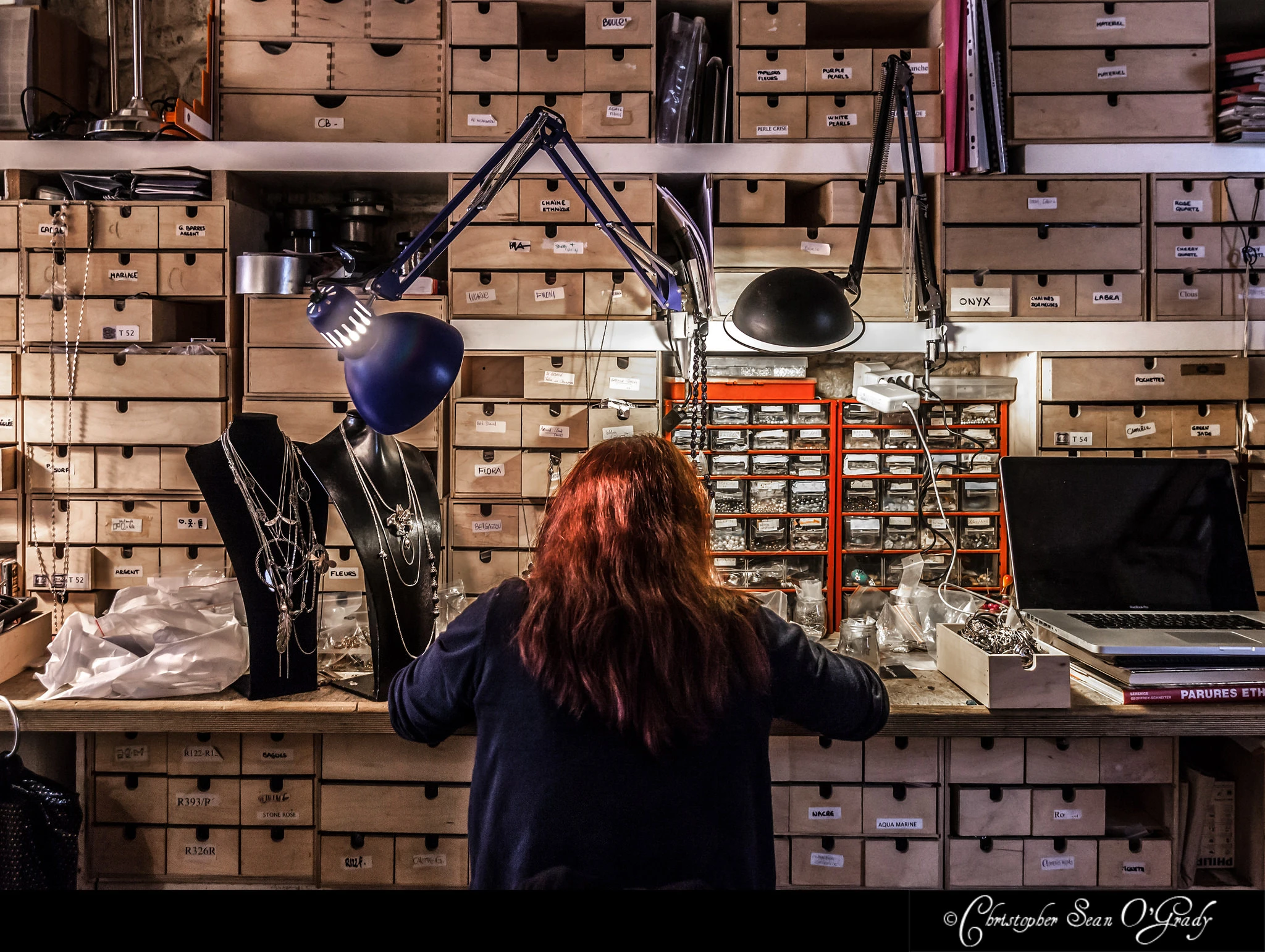 Jewellery maker at assembly station with wooden drawer storage — Lotta Djossou Paris portrait photography