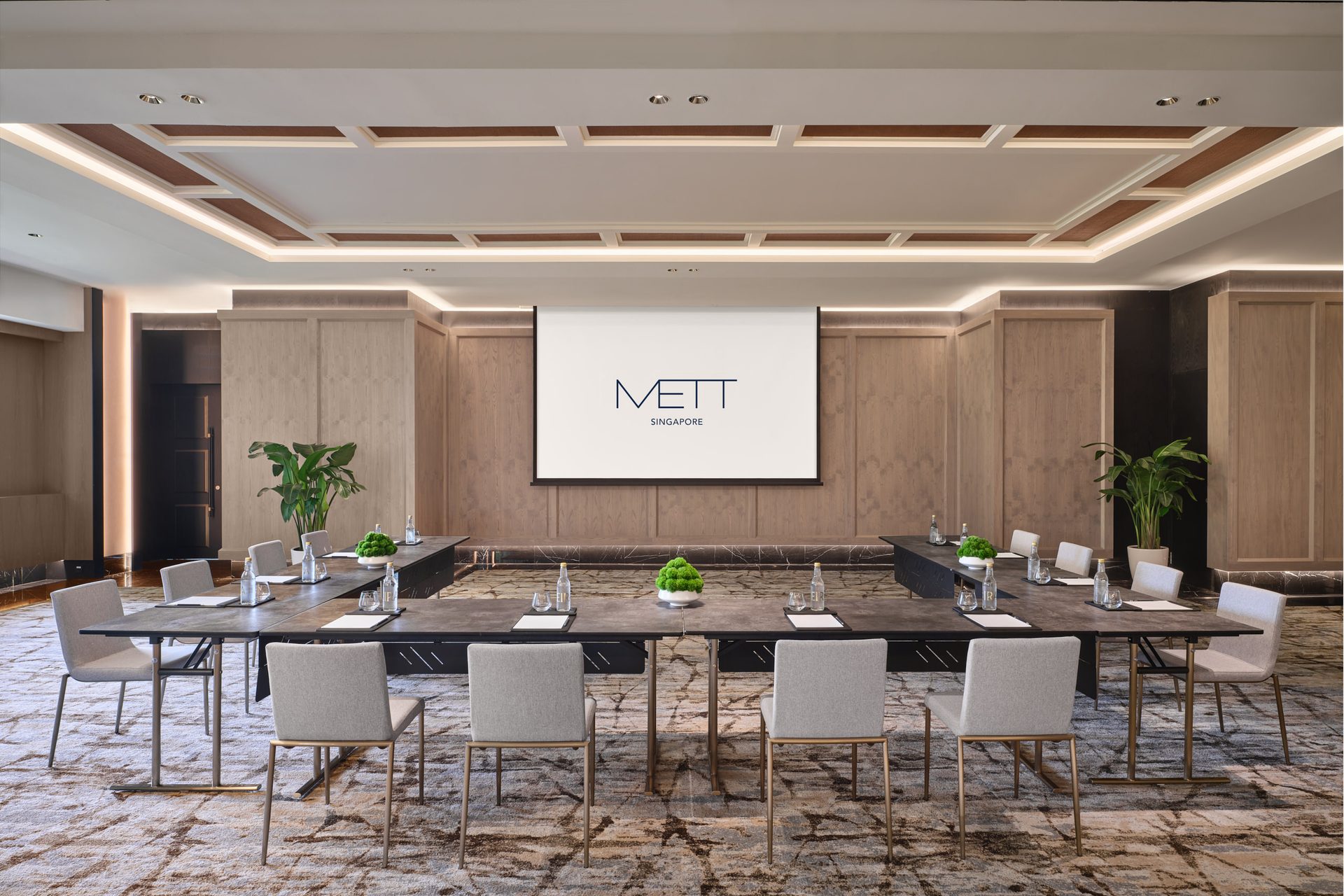 METT Singapore Junior Ballroom U-shape meeting setup with presentation screen, wood wall panelling, potted plants, and hospitality event seating