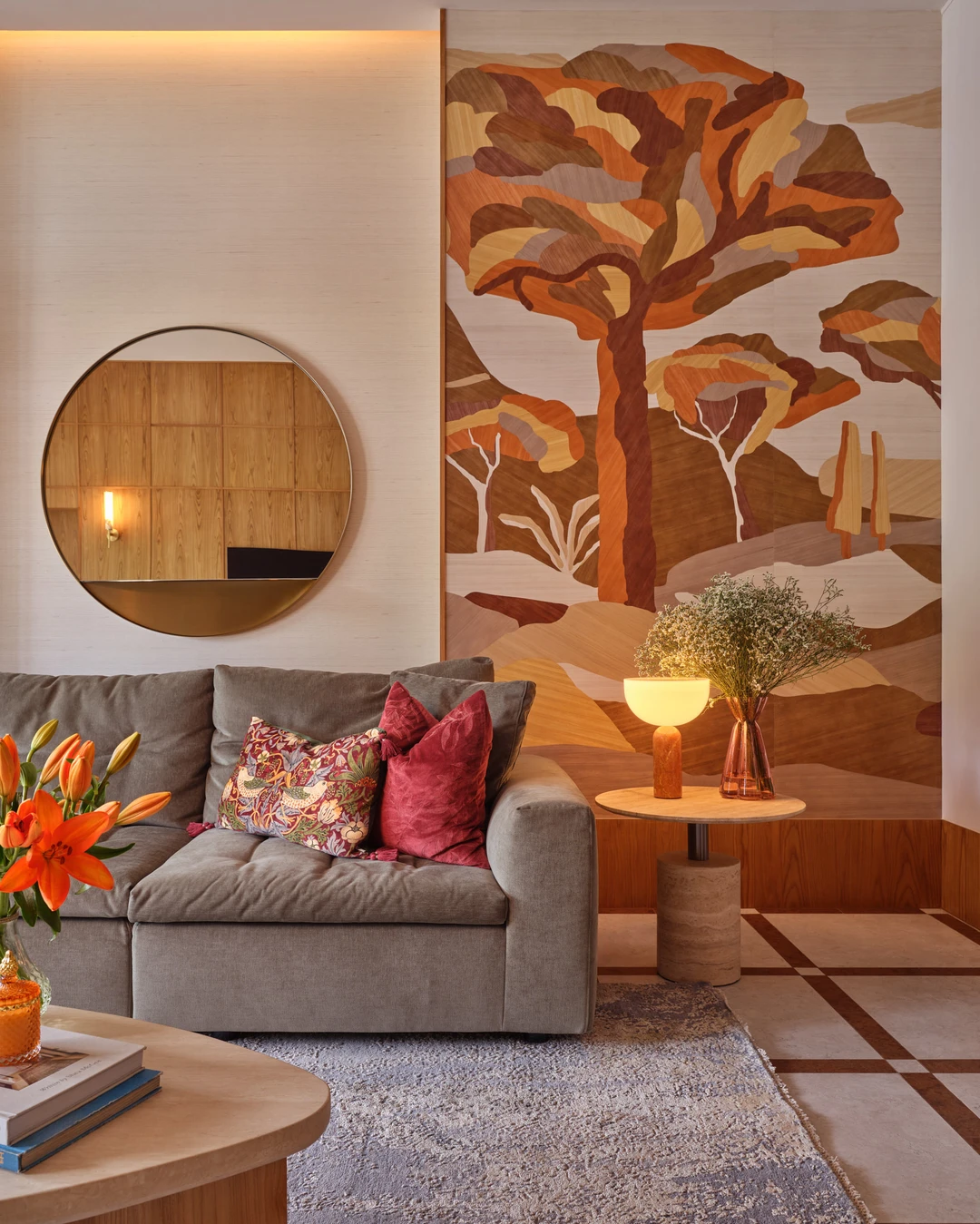 Styled sofa corner in the Bayshore residence by Nidhi Jain with botanical mural, round mirror and layered cushions