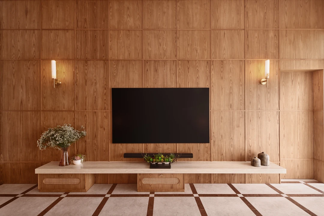 Bayshore residence TV wall by Nidhi Jain with timber paneling, wall sconces and low console joinery, crop detail