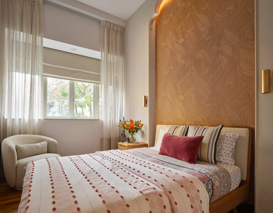 Bayshore bedroom by Nidhi Jain with peach textured headboard wall, striped bedding and soft window light, crop detail