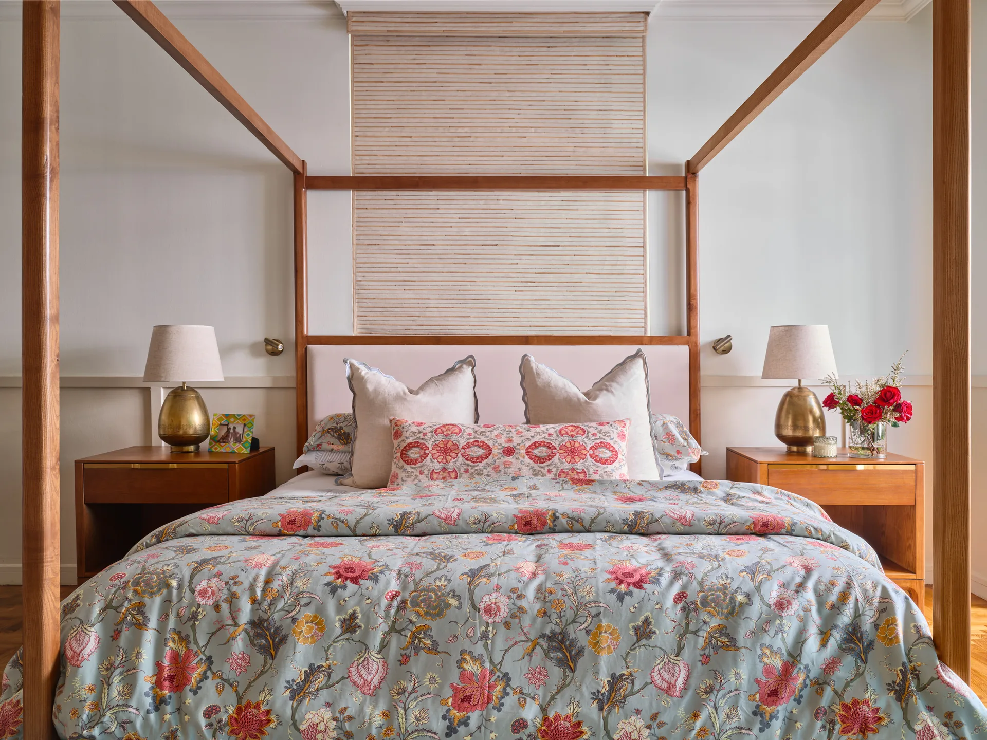 Master bedroom with four-poster bed, floral bedding and cane headboard