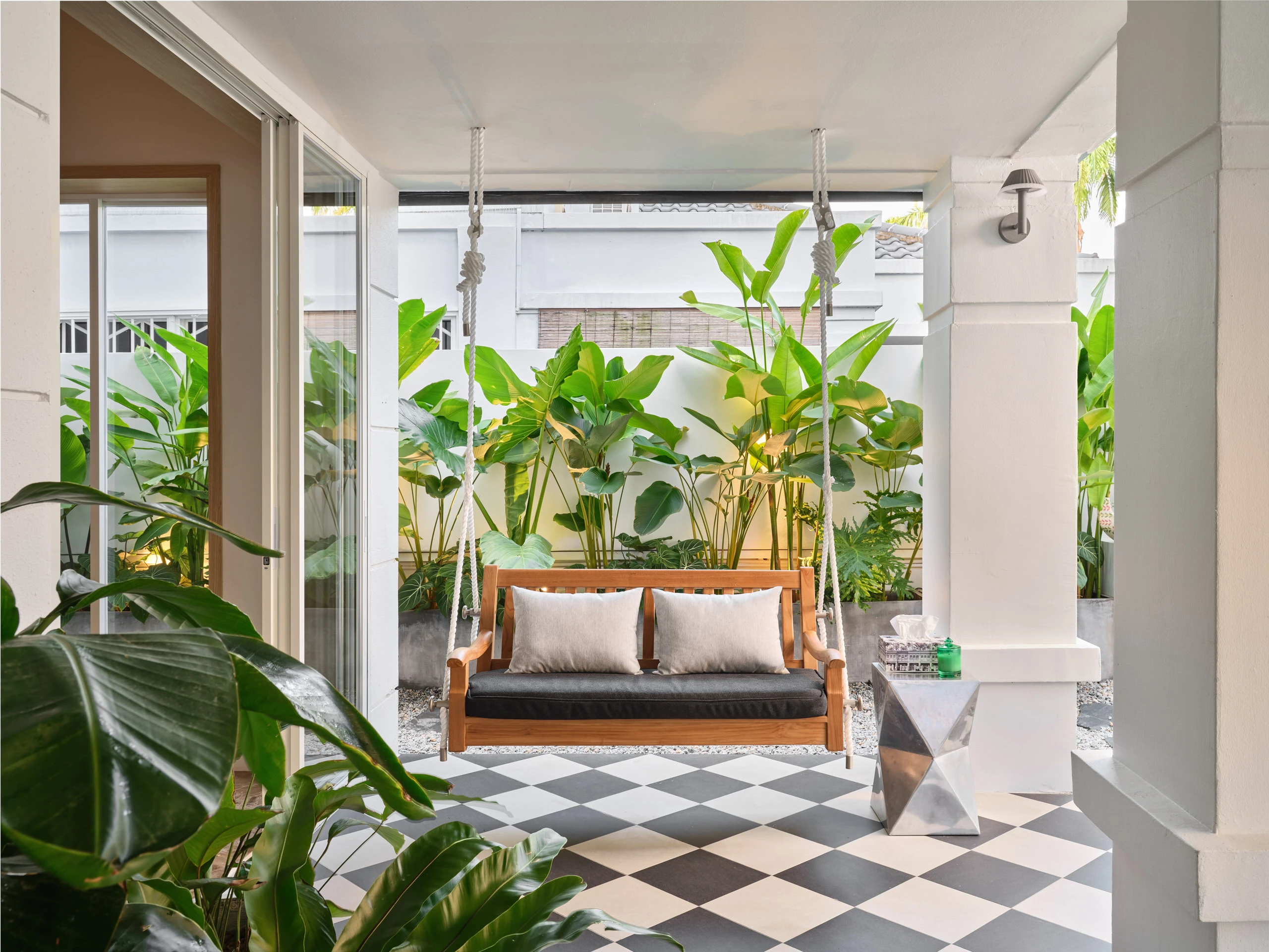 Garden swing seat surrounded by lush tropical greenery