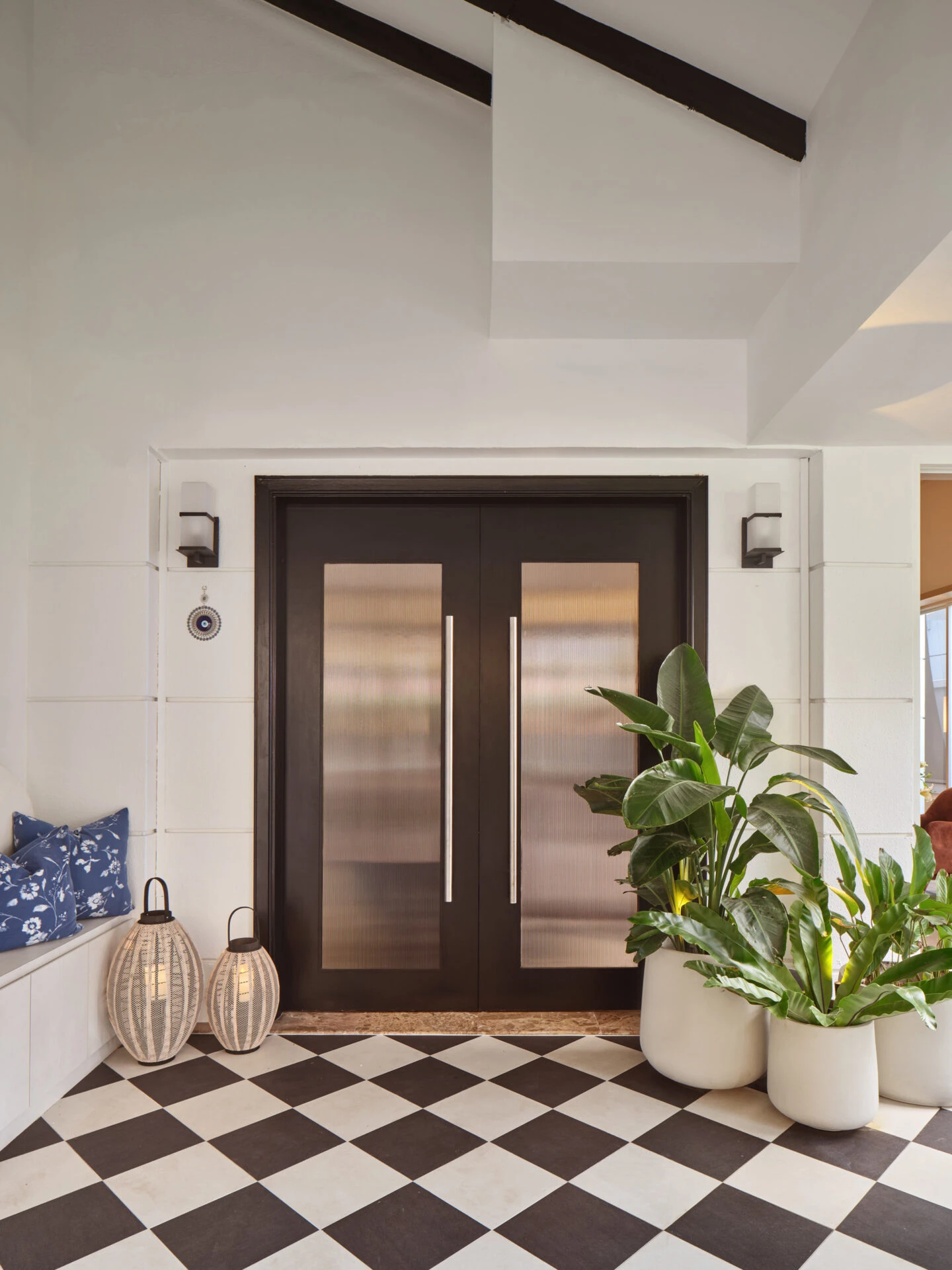 Entrance hall with black and white checkered floor and ornate mirror
