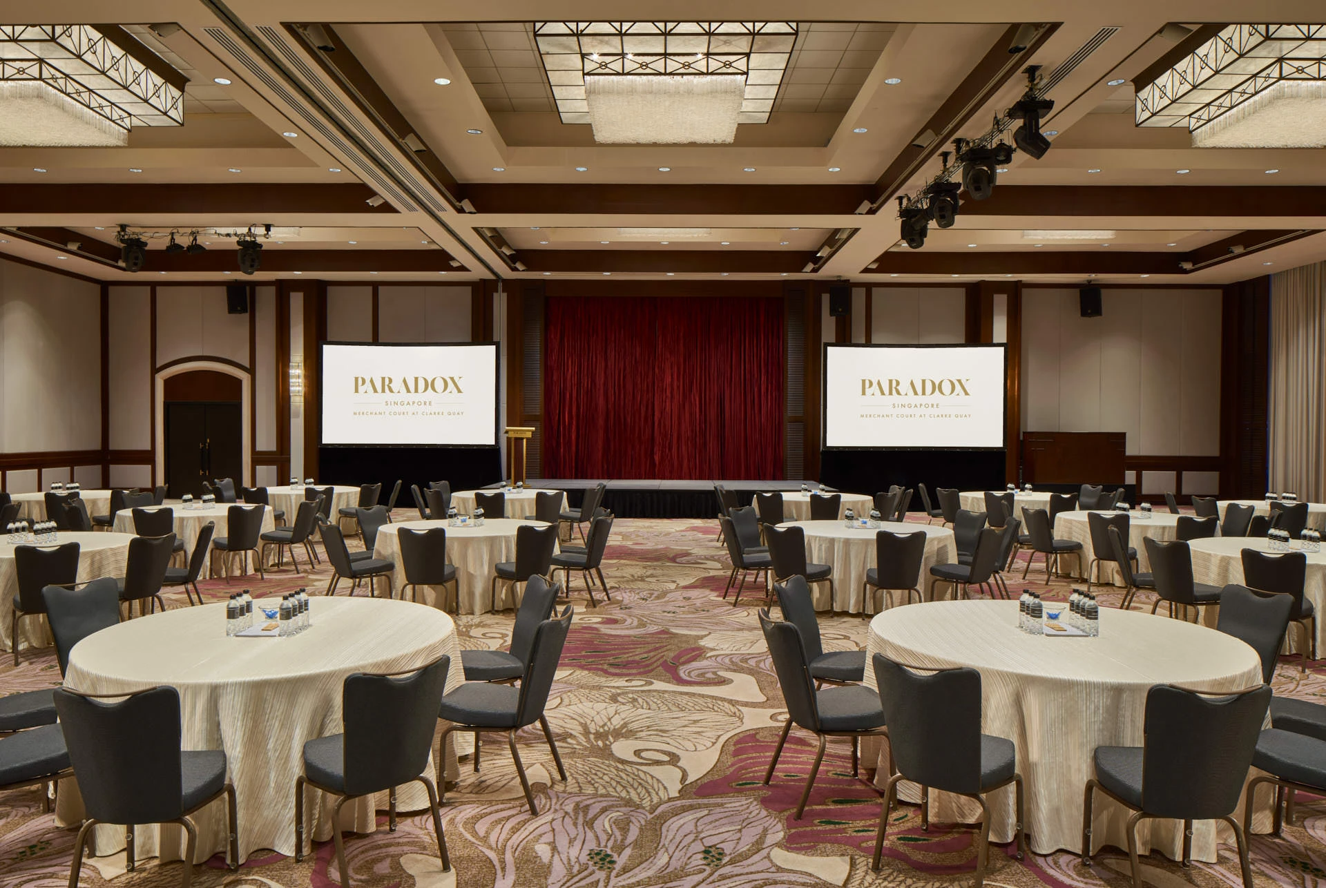 Paradox Singapore ballroom conference in cabaret style with dual screens and stage lighting