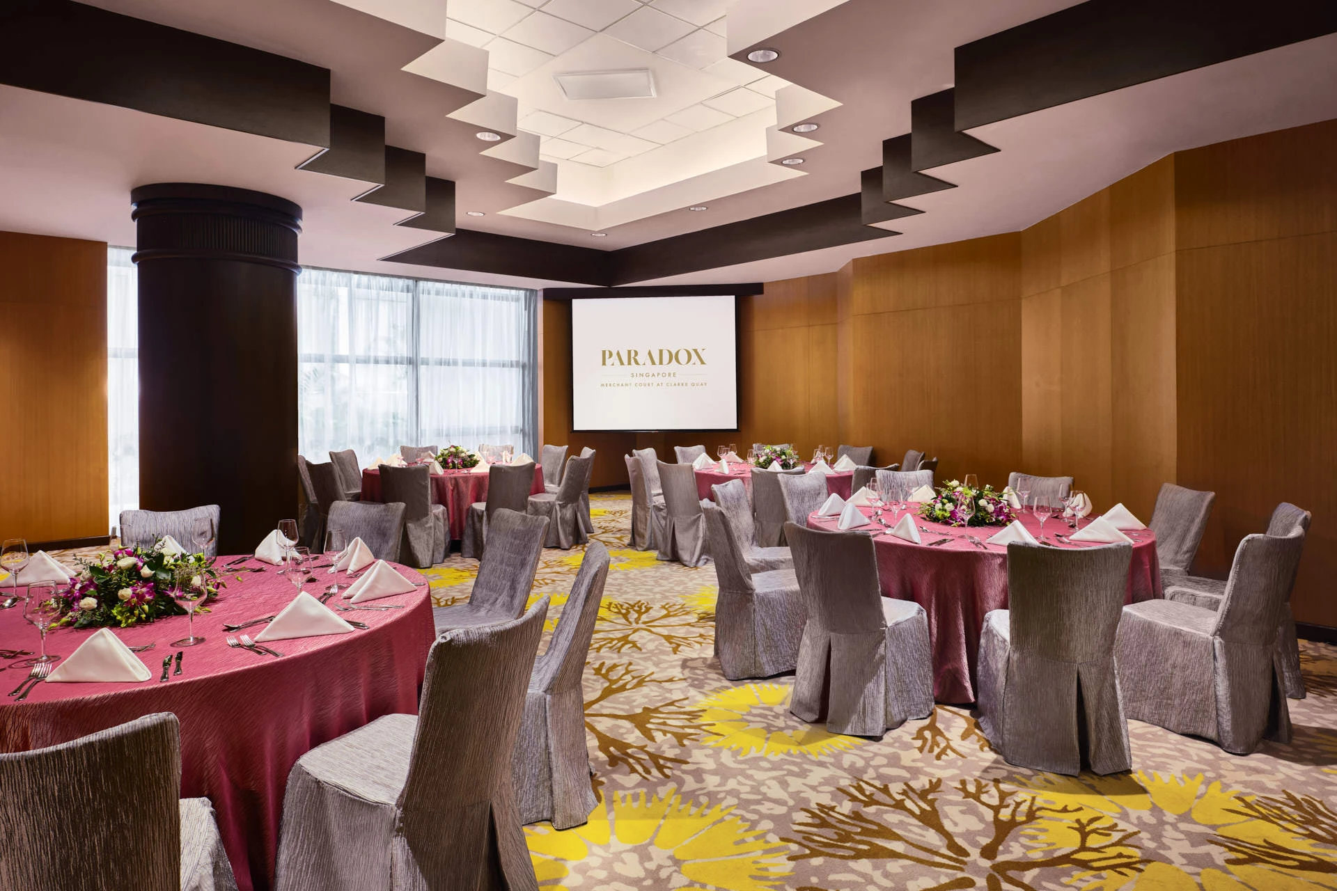 Paradox Singapore Sandalwood Room dinner setup with magenta linens, floral centrepieces, and tiered ceiling