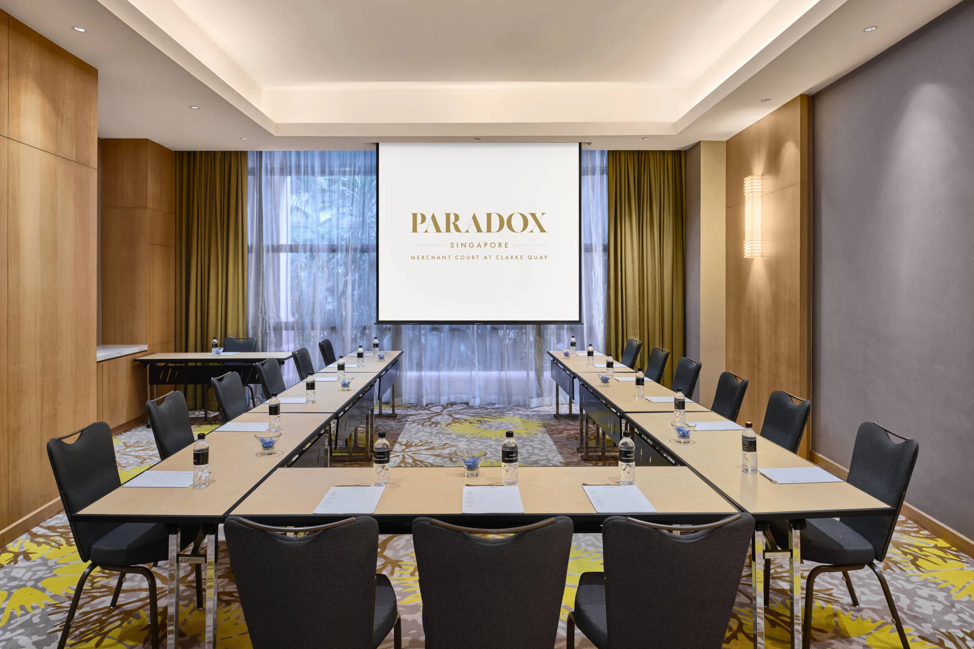 Paradox Singapore Oakwood Room in U-shape setup with natural light and olive curtains