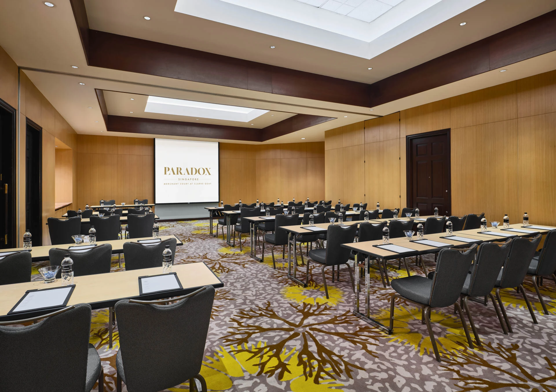 Paradox Singapore Rosewood Room classroom setup with branded screen and timber panels