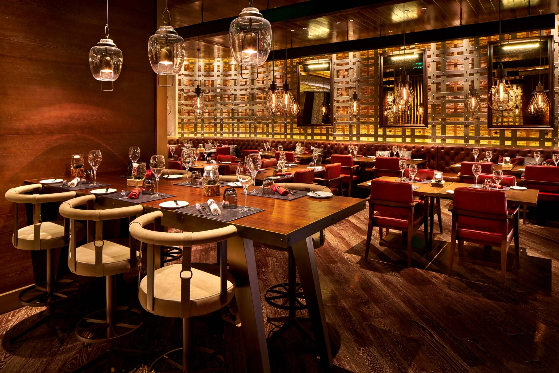 High-top bar with cream stools, glass pendants and metalwork screen