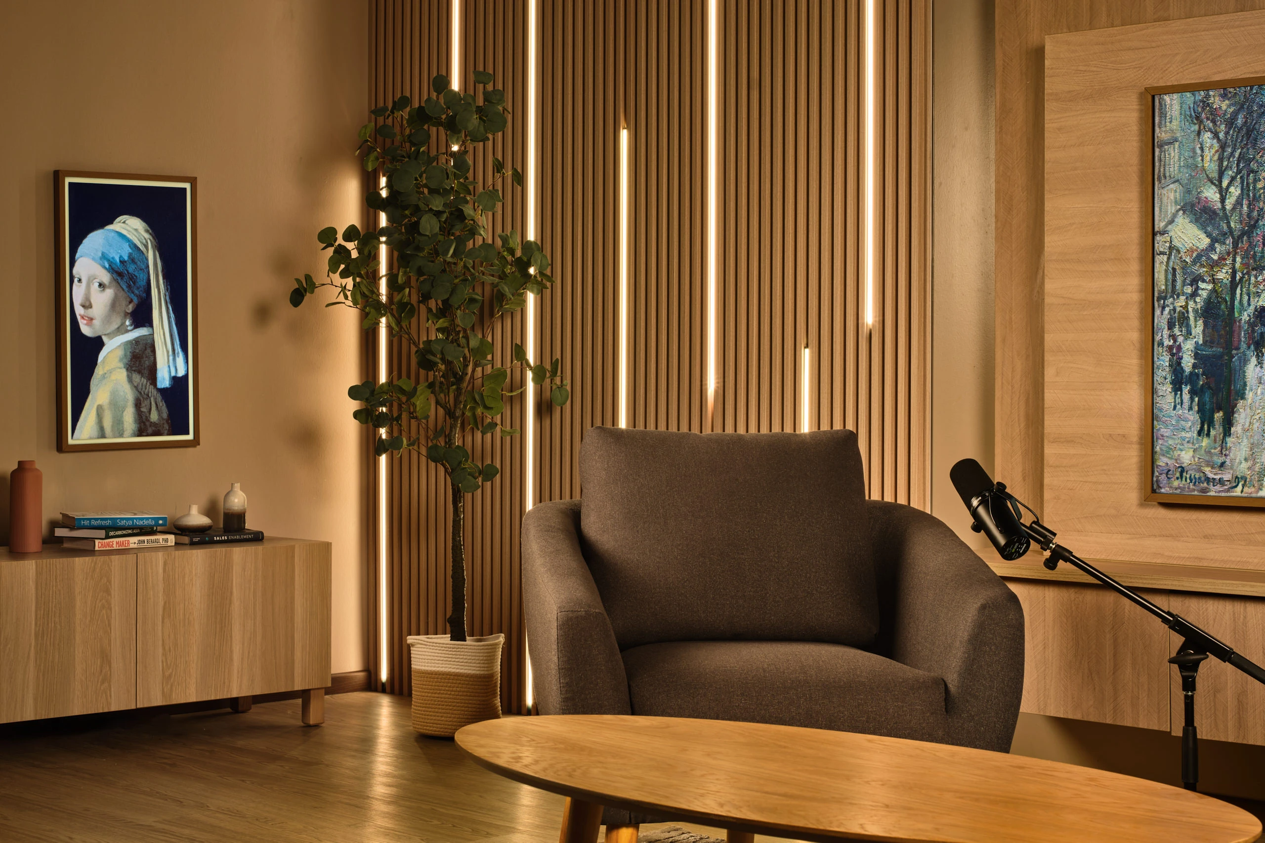 Warm studio detail with acoustic slat wall, microphones and Impressionist art