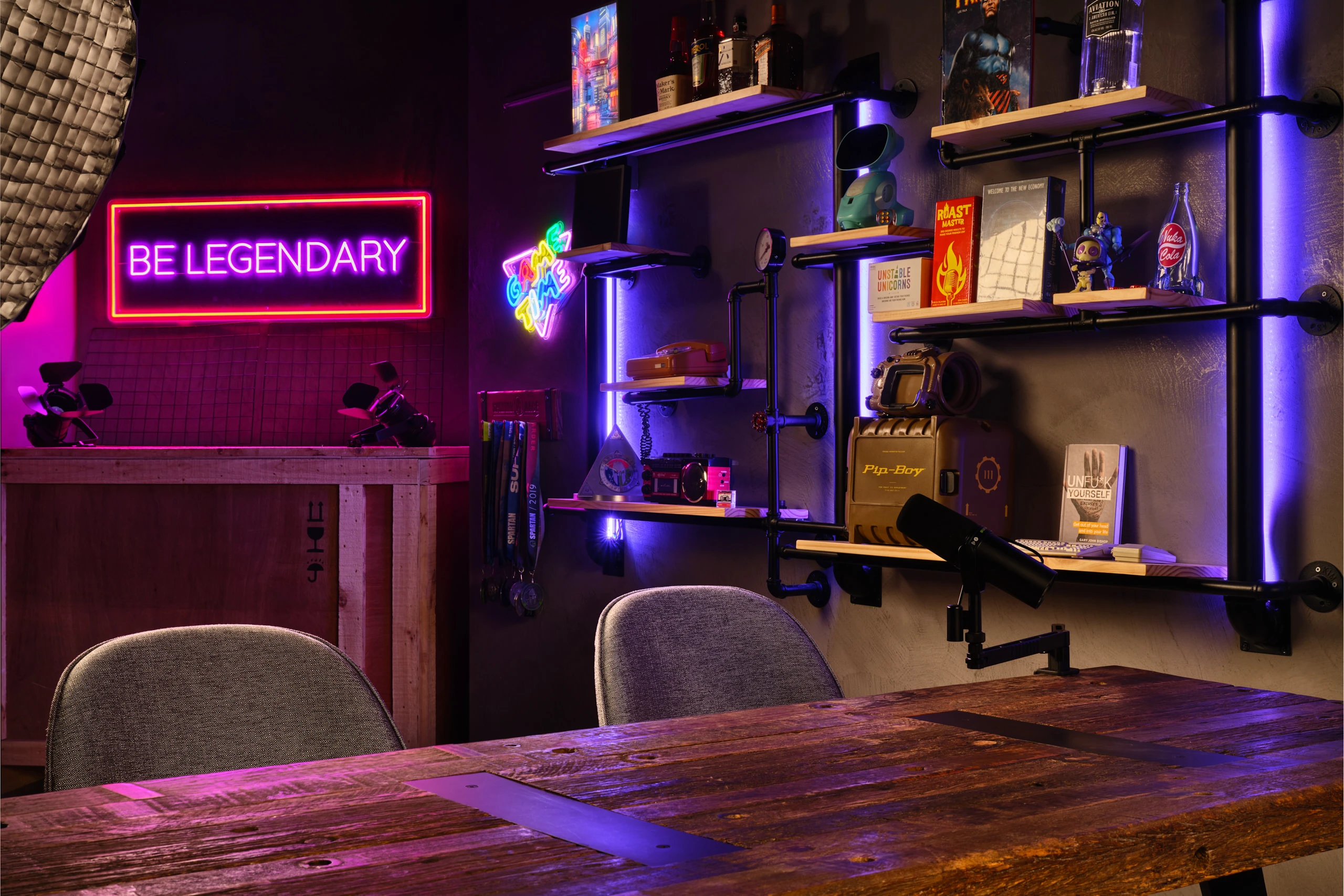 Gaming studio detail with Deadpool bust, neon signs and microphones