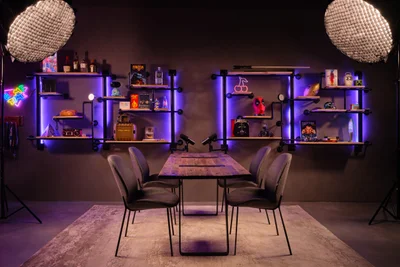 Industrial gaming podcast studio with purple LED pipe shelving and pop culture memorabilia