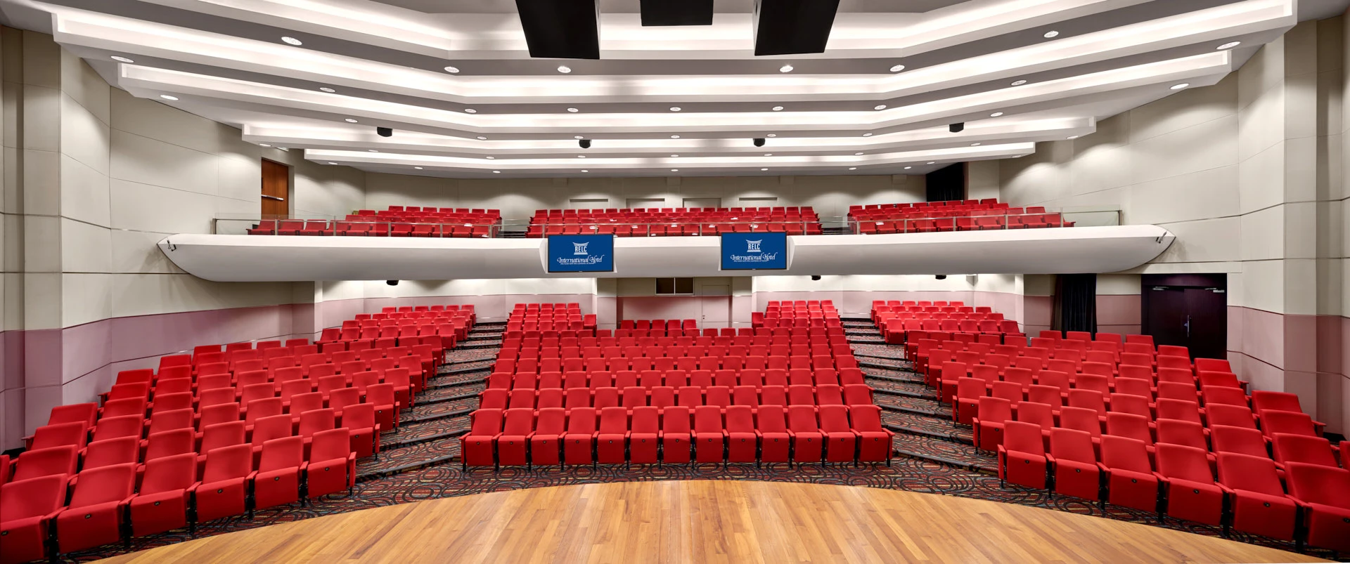 Two-level auditorium from stage with branded monitors and LED ceiling