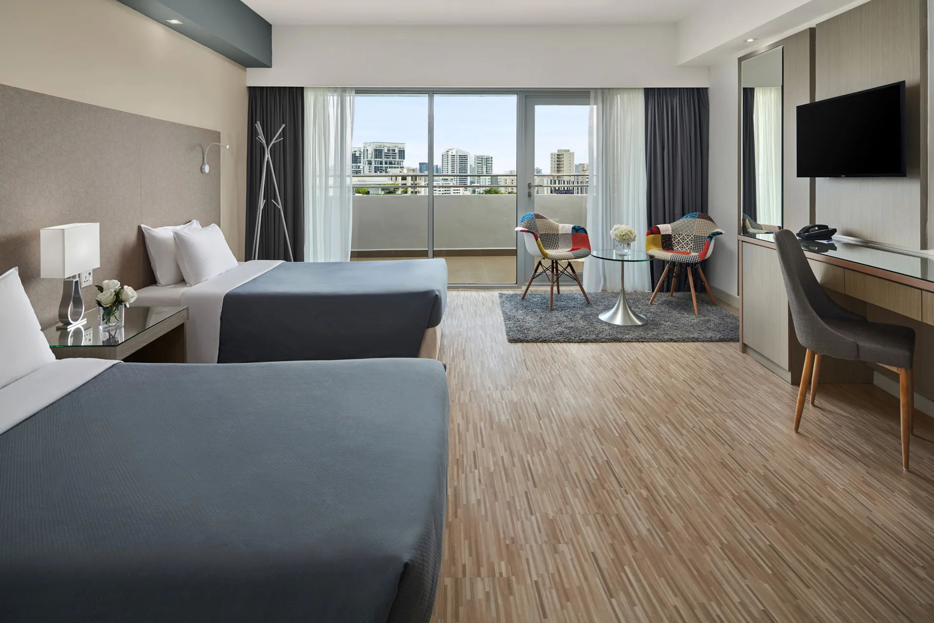 Twin room with Eames chairs, glass table and balcony views
