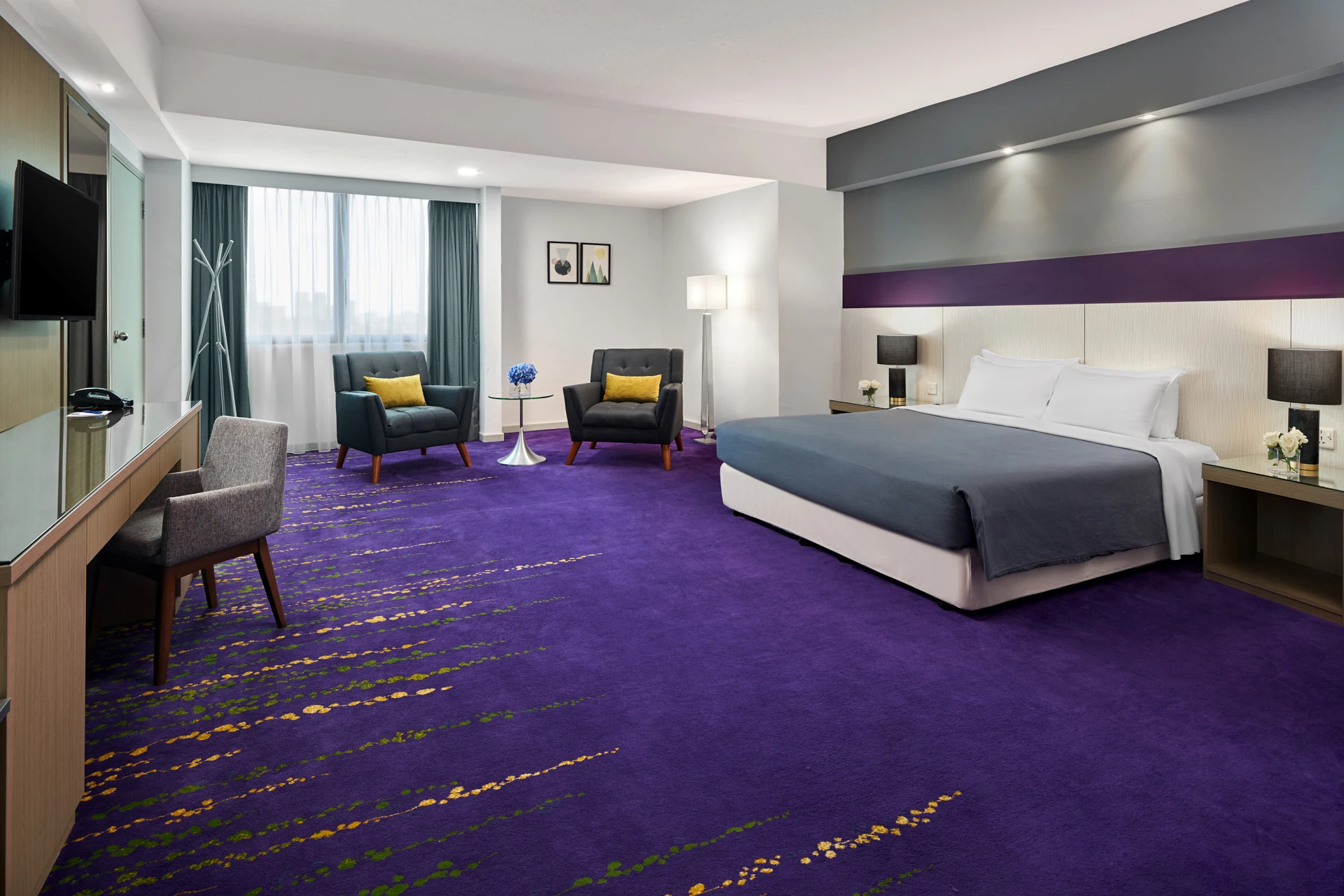 King room with dark armchairs, tulip table and warm floor lamp