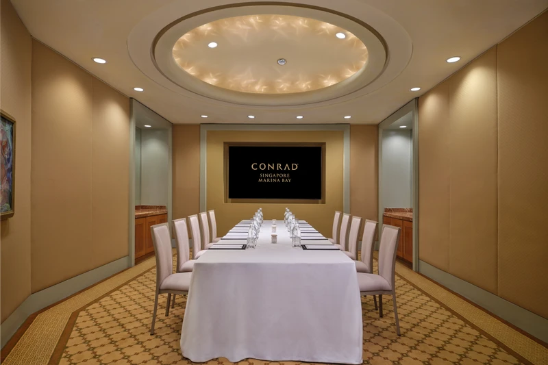 Conrad Singapore Marina Bay Salon 1 in boardroom setup with intimate meeting room seating and soft hotel lighting