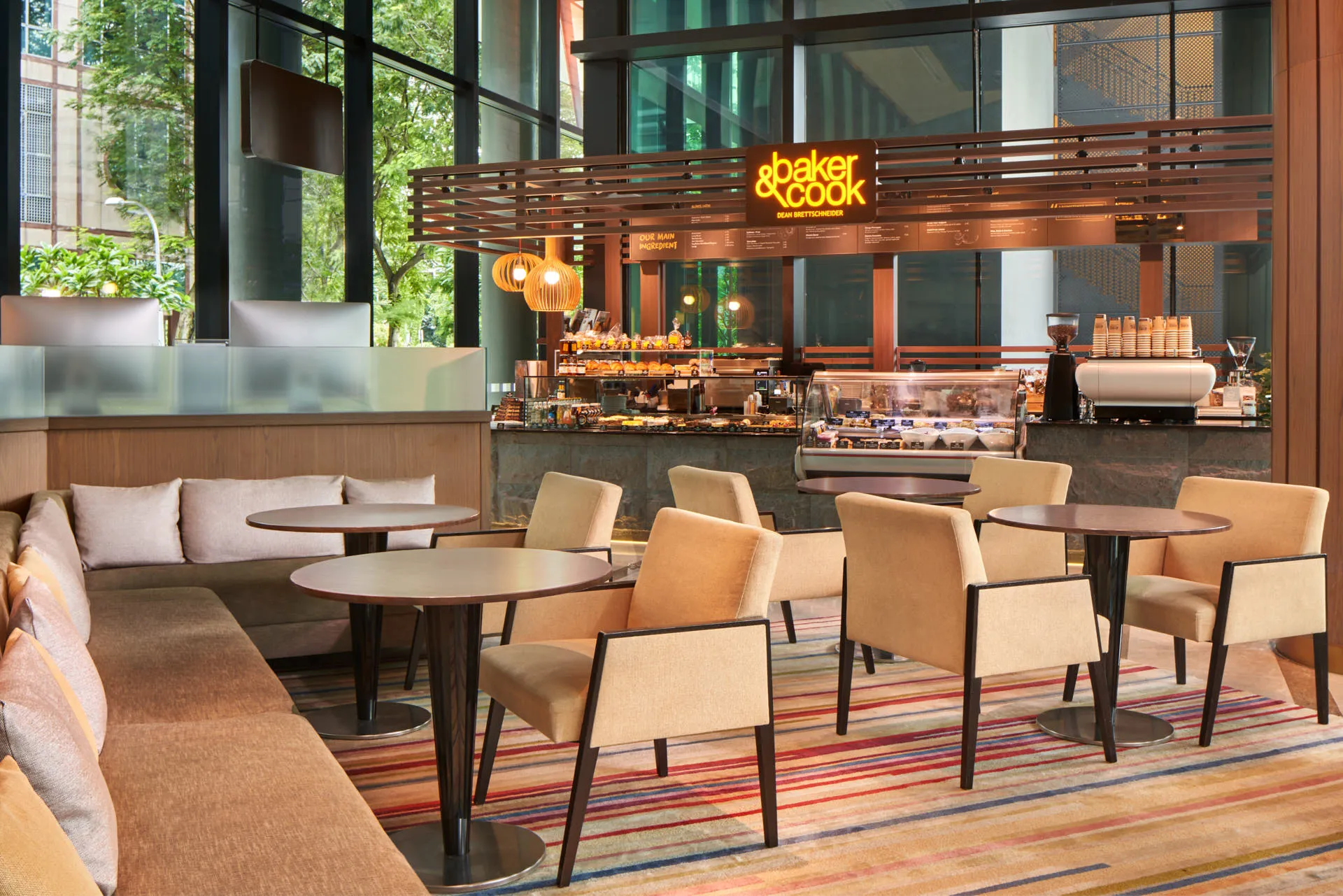 Baker and Cook cafe with pastry counter and striped rug seating area — Holiday Inn Express Clark Quay hotel photography