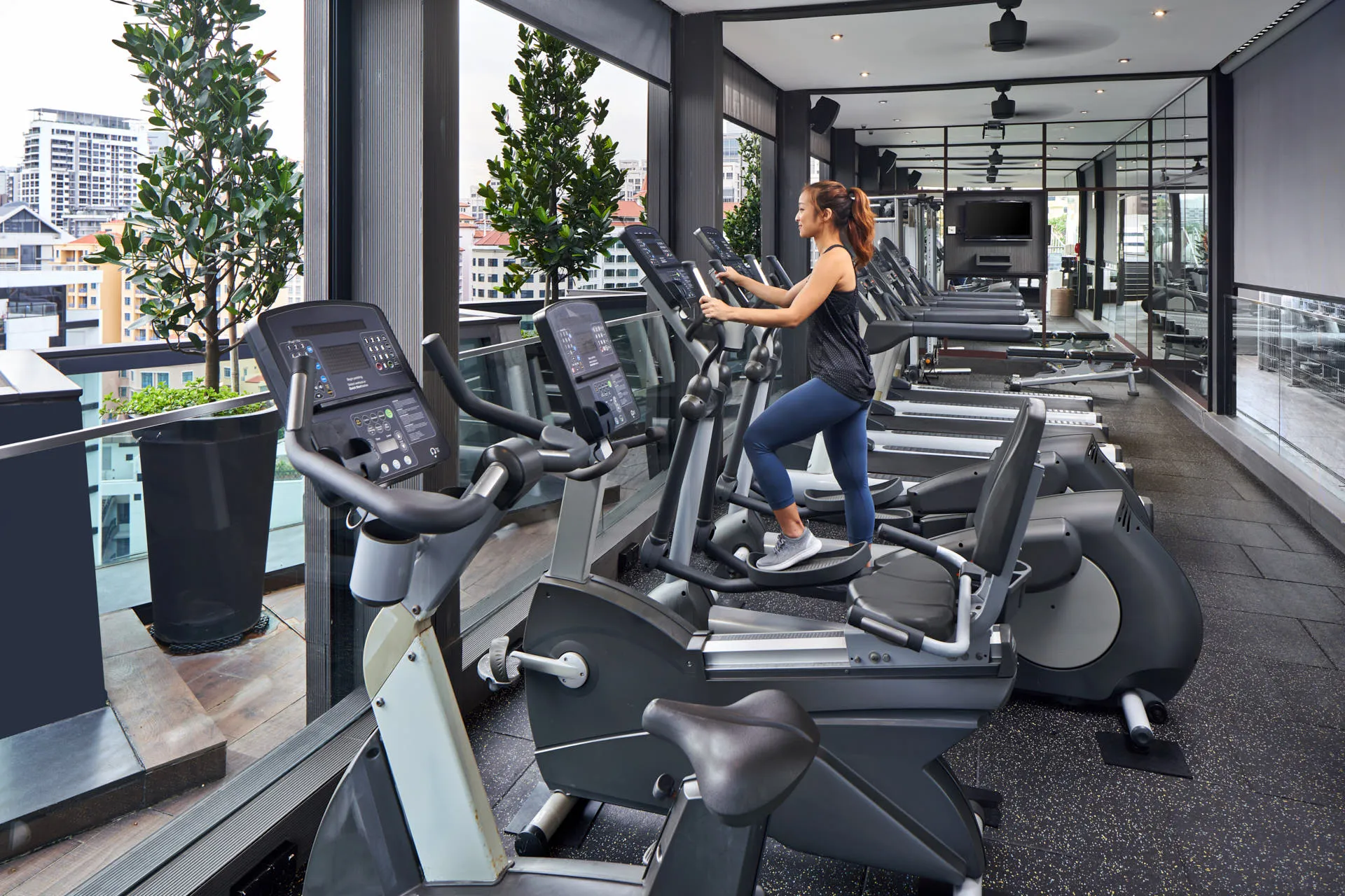 Guest exercising on rooftop fitness centre with city panorama — Holiday Inn Express Clark Quay lifestyle photography