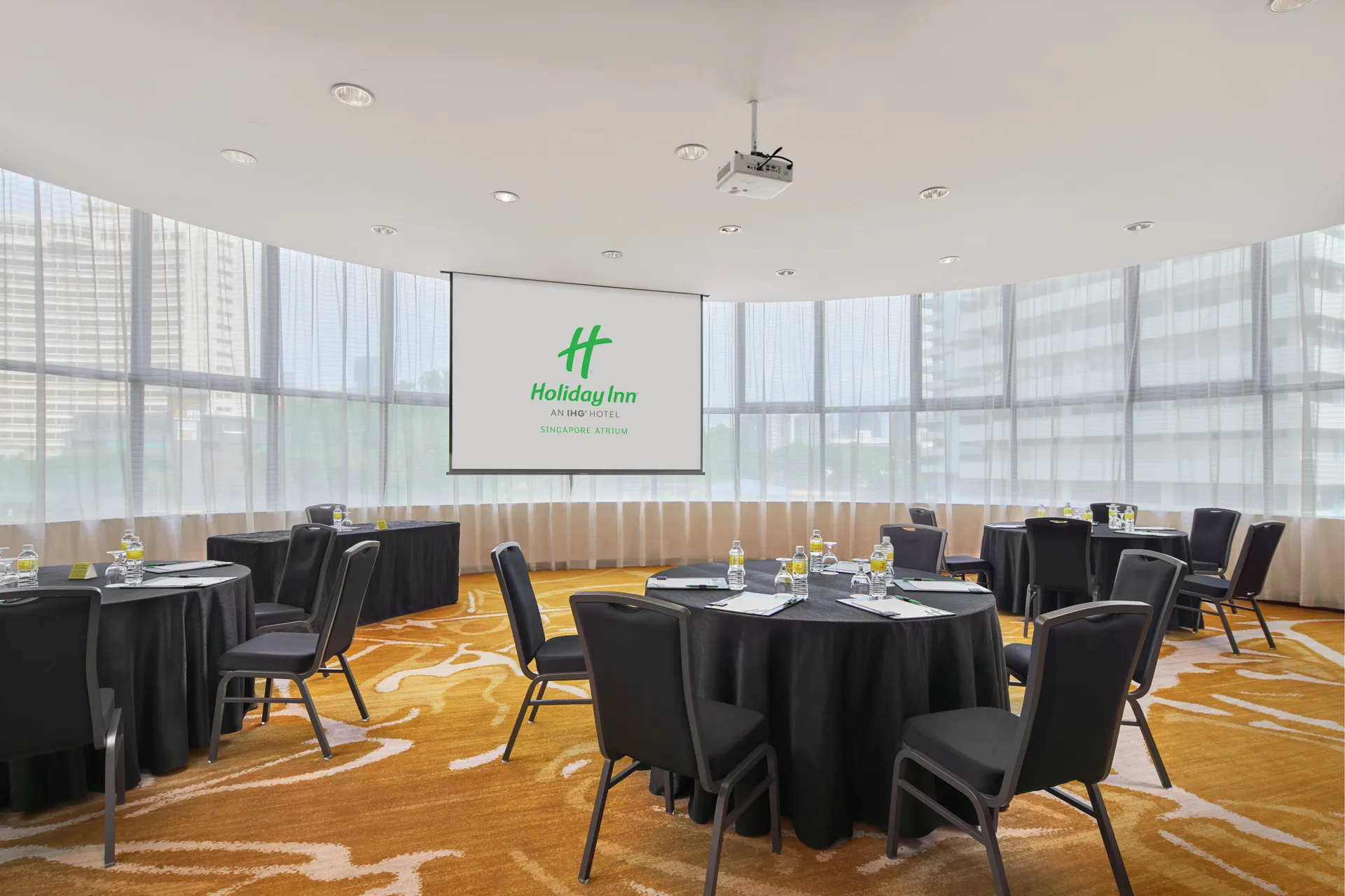 Curved meeting room in cabaret rounds with sheer curtains and natural light — Holiday Inn Atrium function room photography