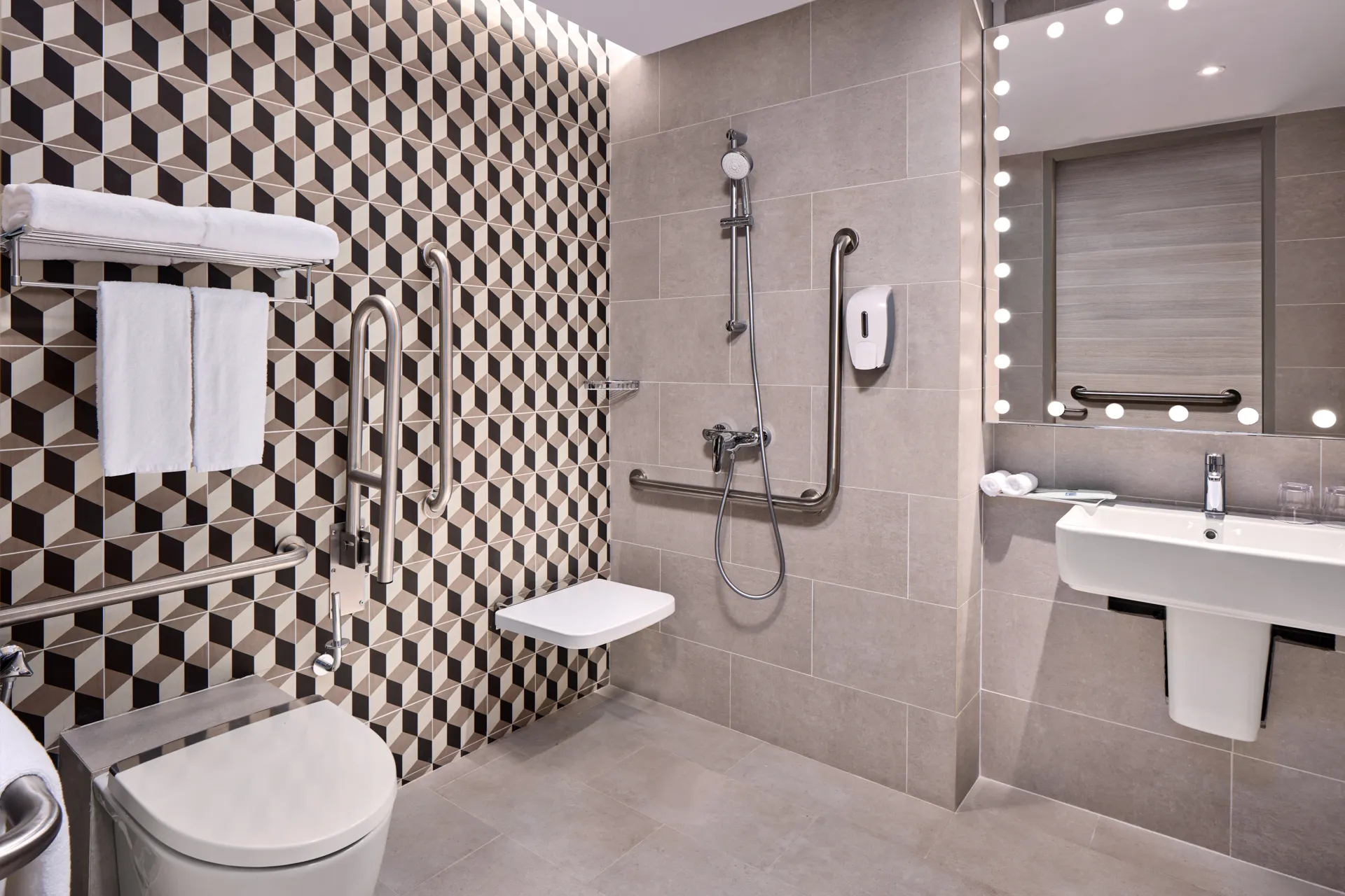 Accessible bathroom with roll-in shower, grab bars and globe-lit vanity mirror — Holiday Inn Express Serangoon hotel photography