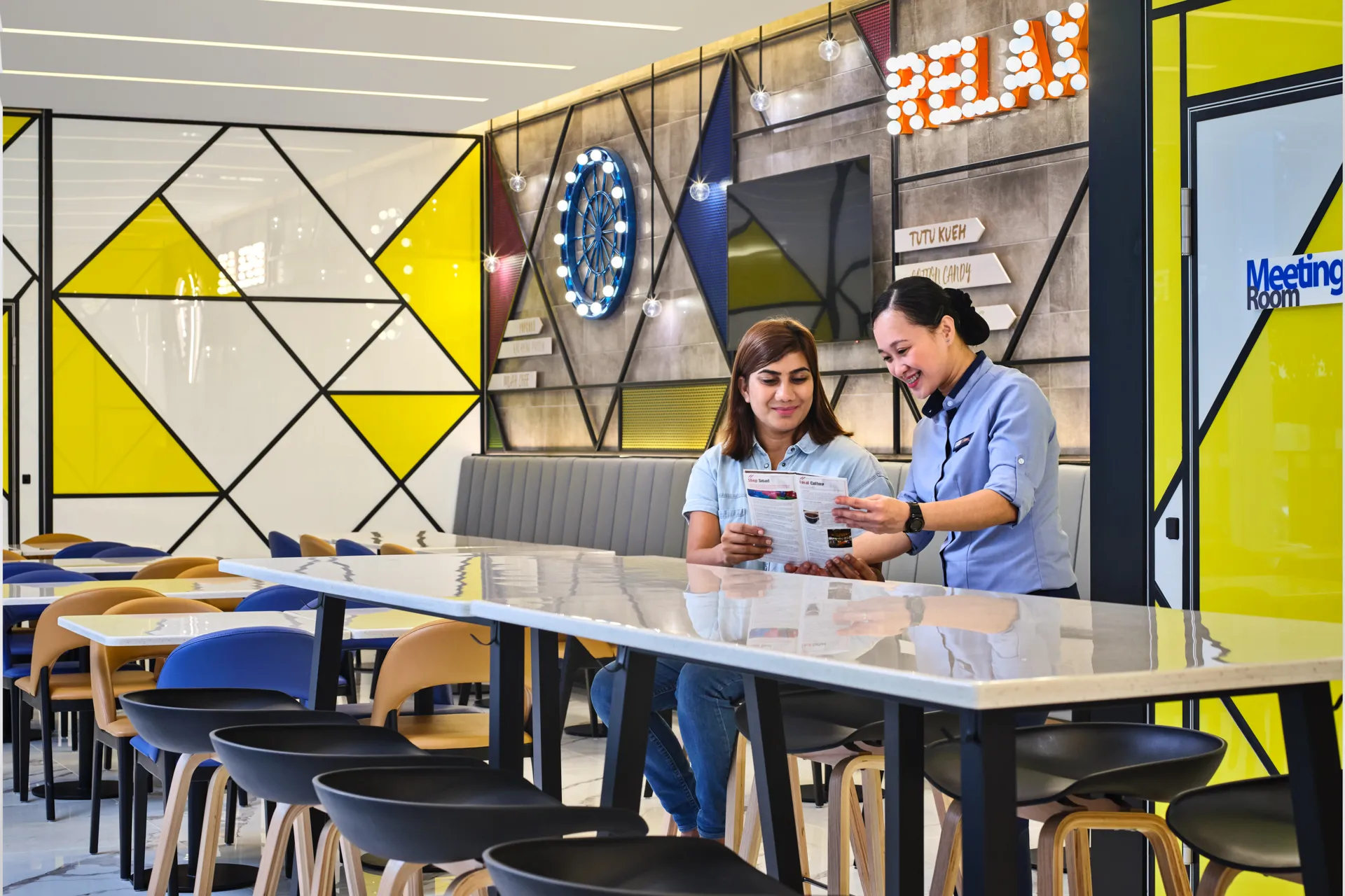 Guest and staff reviewing brochure in hotel lounge — Holiday Inn Express Serangoon lifestyle photography