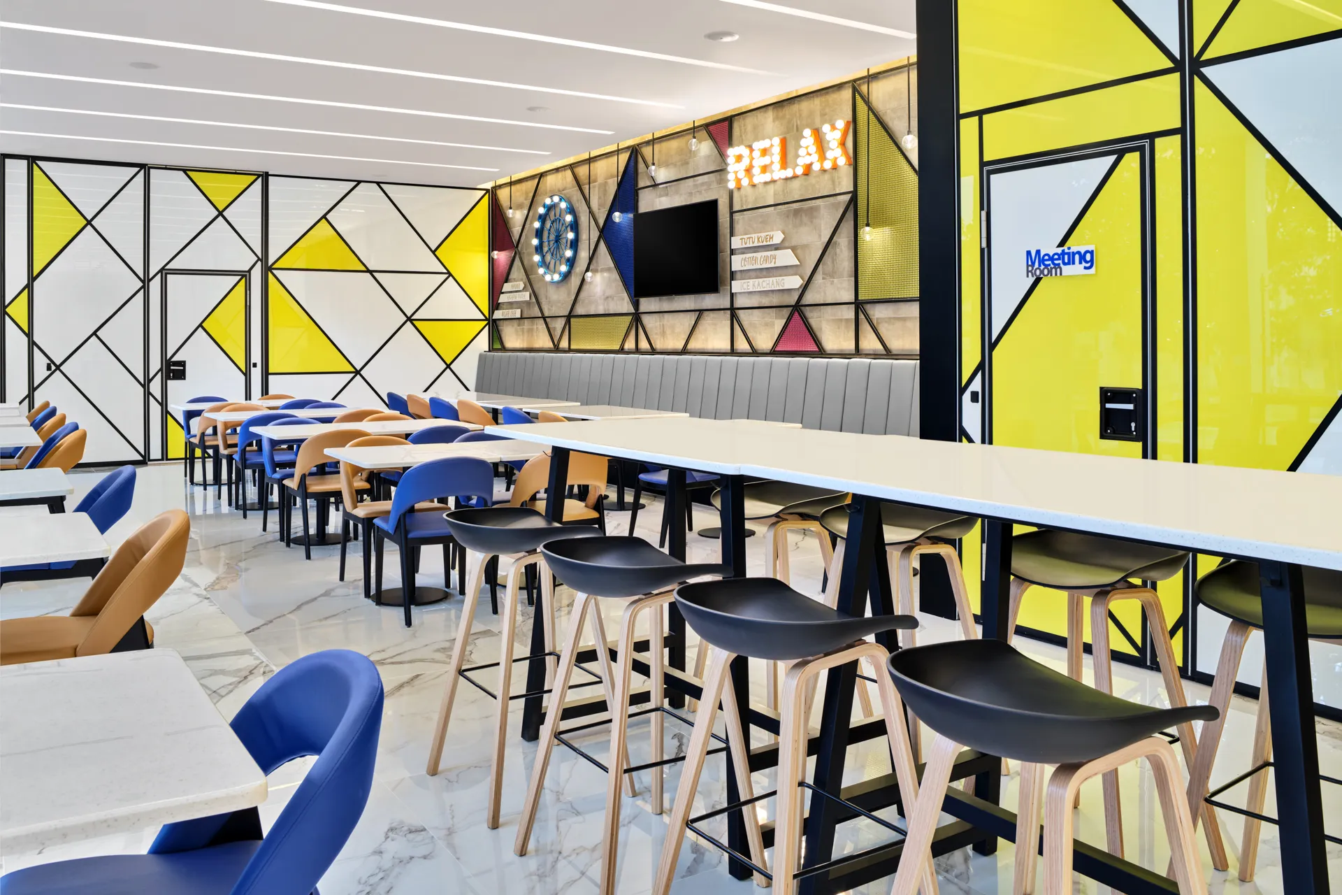 Lounge with communal bar, dining tables and geometric partitions — Holiday Inn Express Serangoon hospitality photography