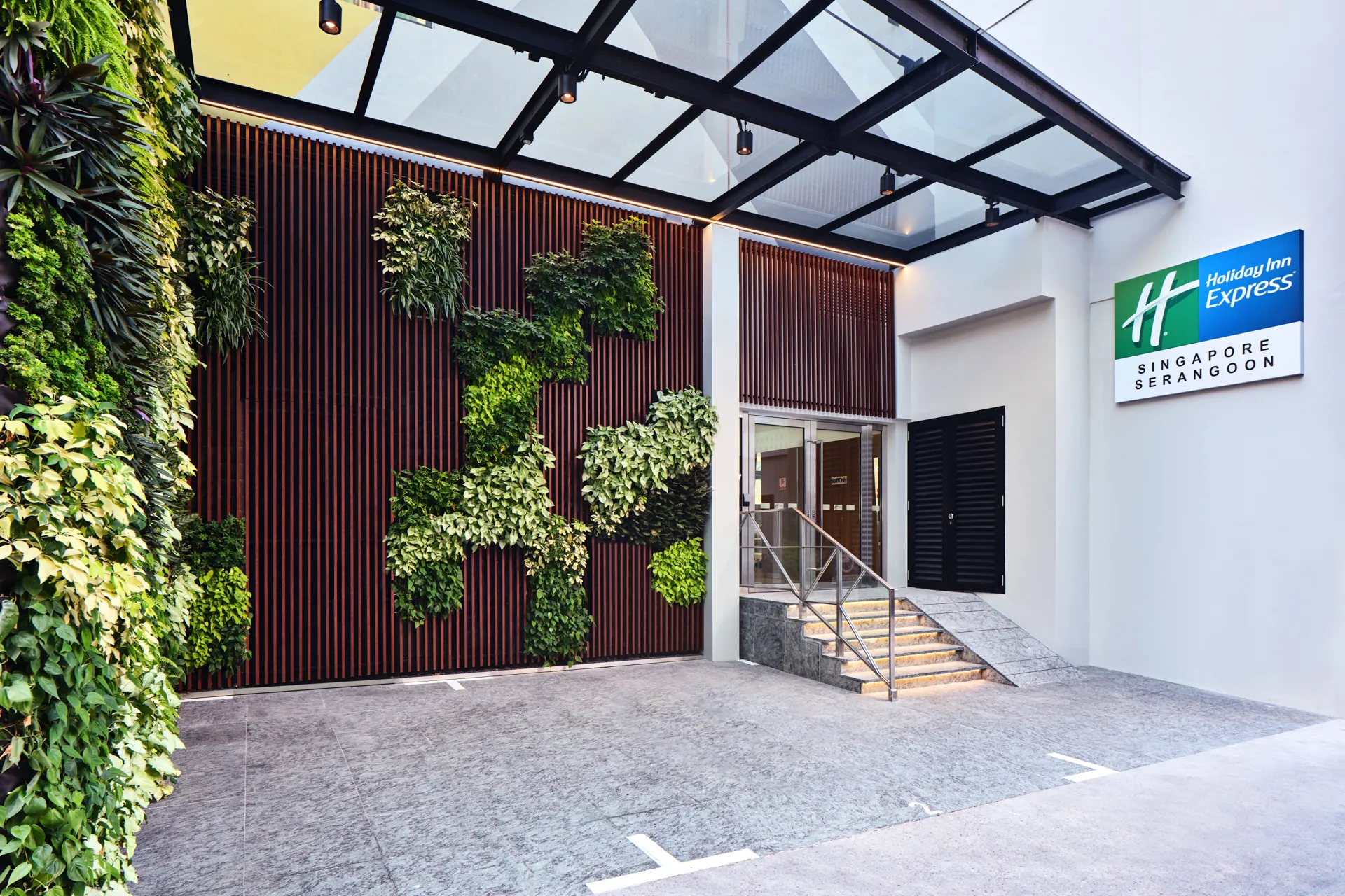 Hotel entrance with green living wall and timber slat panels — Holiday Inn Express Serangoon architectural photography
