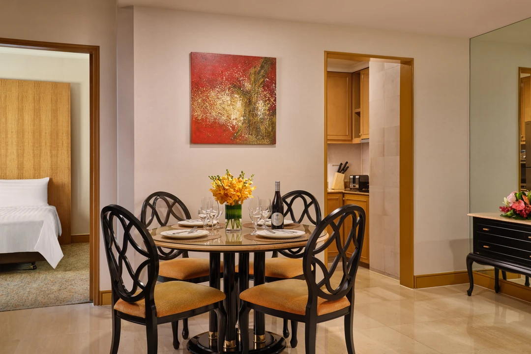 Elegant dining area with round table, wine and kitchen access, Shangri-La Residences Singapore