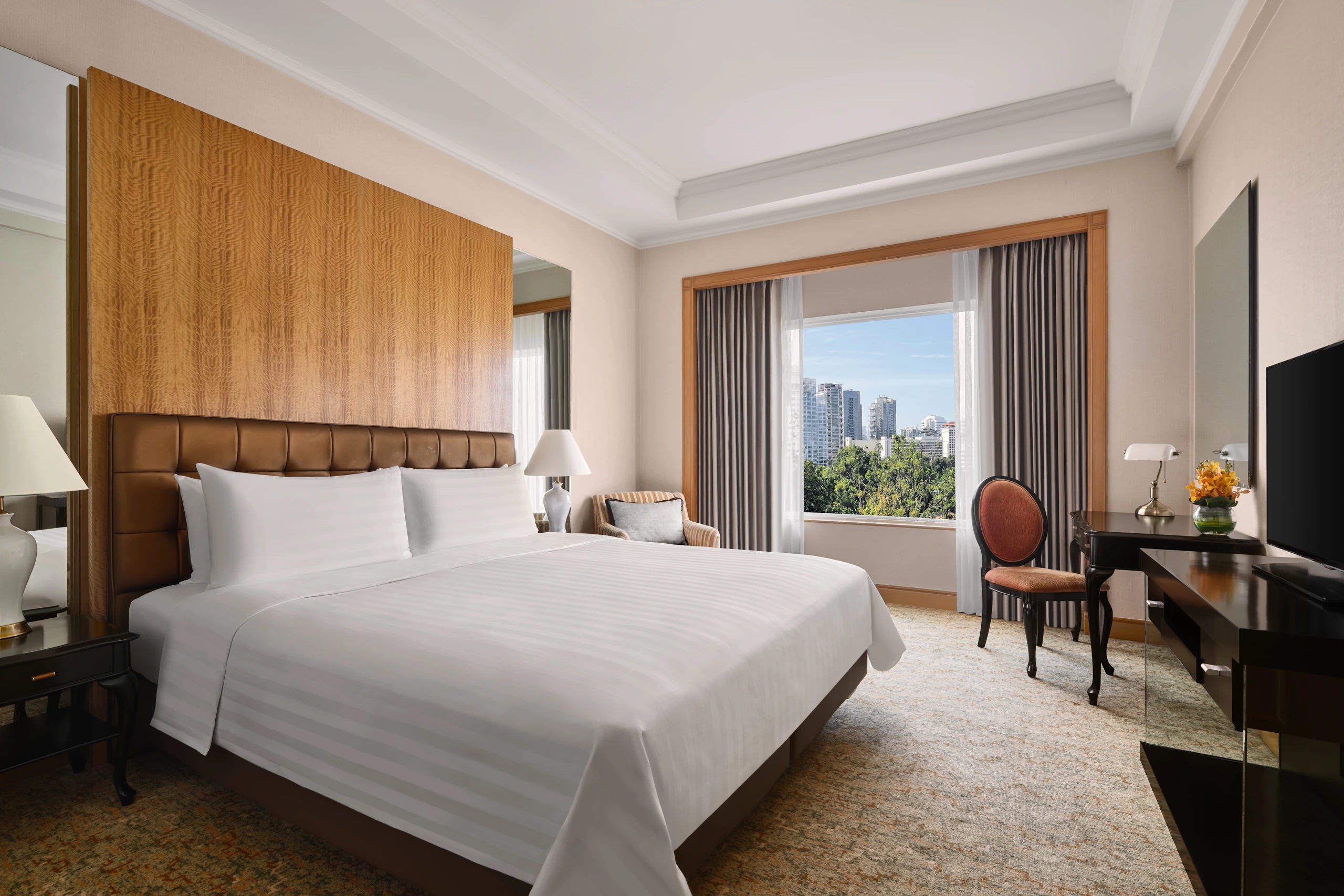 King bedroom with leather headboard, desk and city skyline view, Shangri-La Residences Singapore