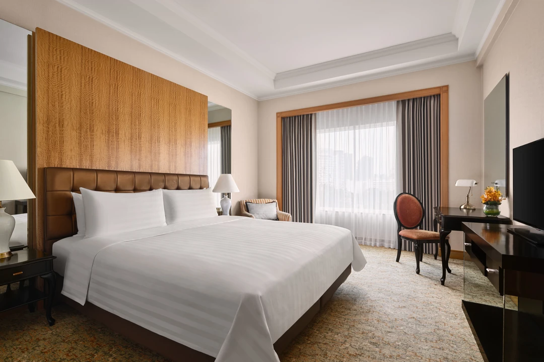 King bedroom with tufted headboard, wood paneling and desk, Shangri-La Residences Singapore