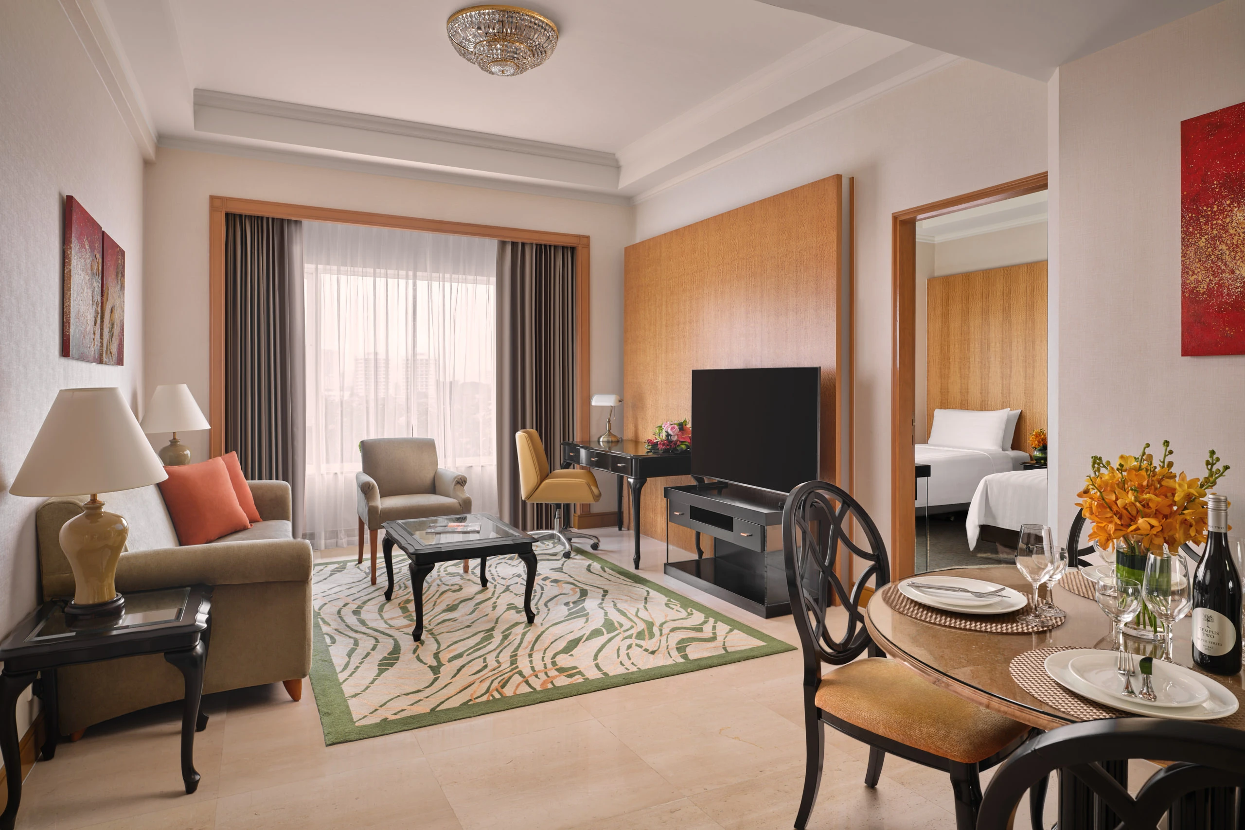 Suite living room with sofa, patterned rug and adjoining bedroom, Shangri-La Residences Singapore