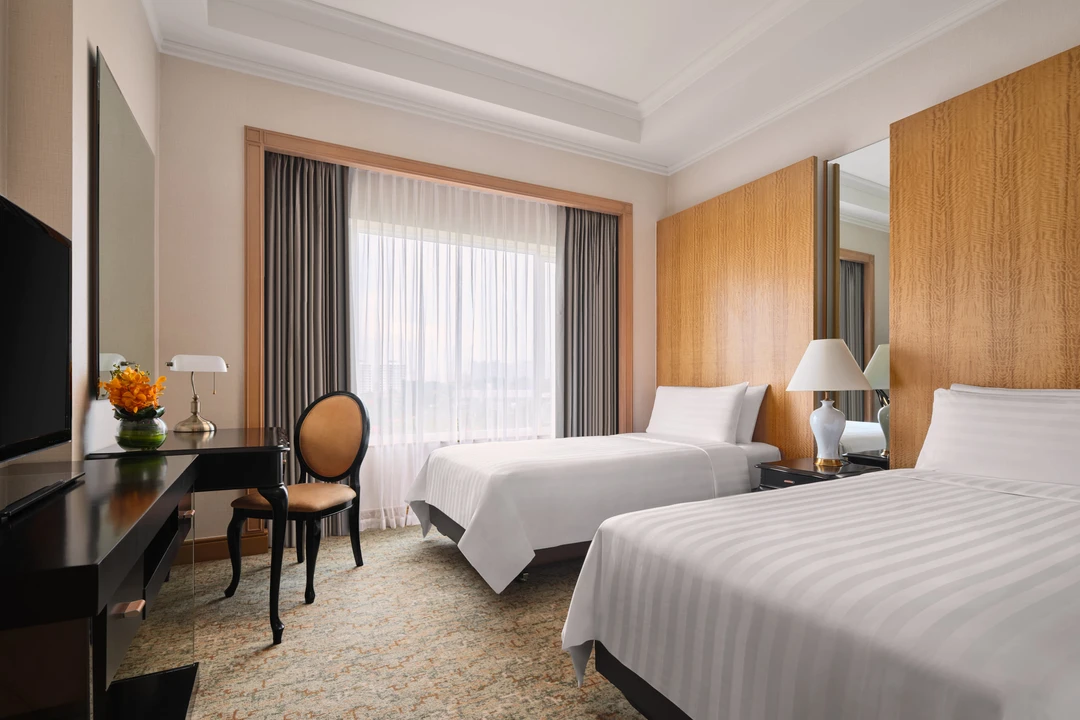 Twin bedroom with wooden headboard, desk and sheer curtains, Shangri-La Residences Singapore