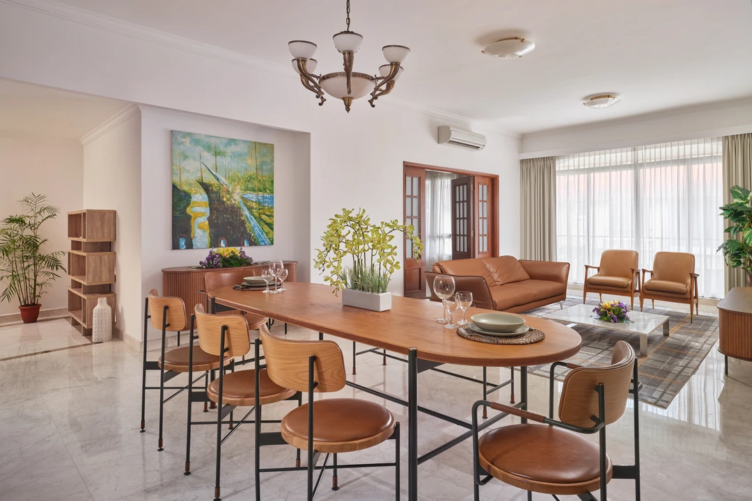 Open-plan dining and living area with wooden table and art, Shangri-La Residences Singapore
