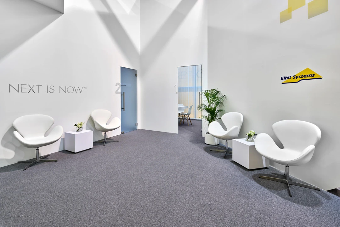 Elbit Systems hospitality corridor with angular lighting and private rooms