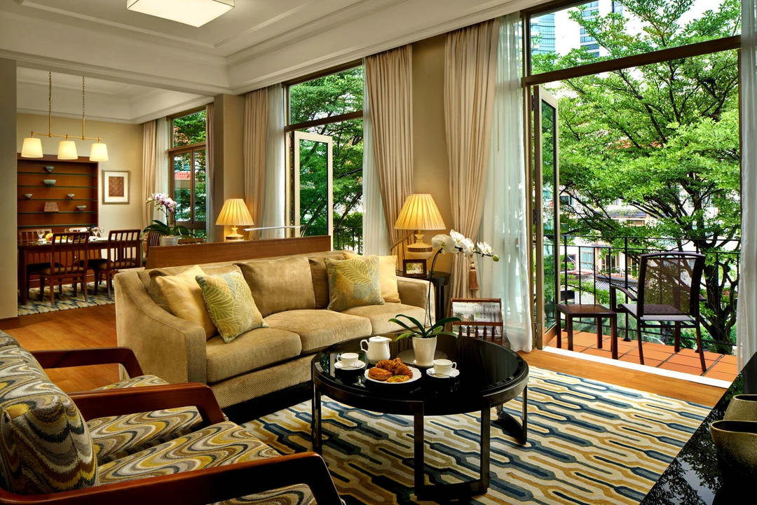 Double-height living room with gold sofa, French doors and formal dining beyond - Treetops Singapore interior photography