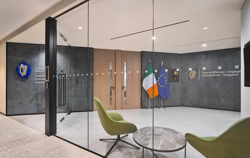 Ireland House Singapore lobby with Irish and EU flags, green chairs and glass walls