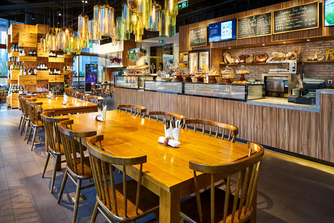 Rustic cafe with oak tables, pastry counter and coloured glass pendants — Crowne Plaza Beijing Lido restaurant photography