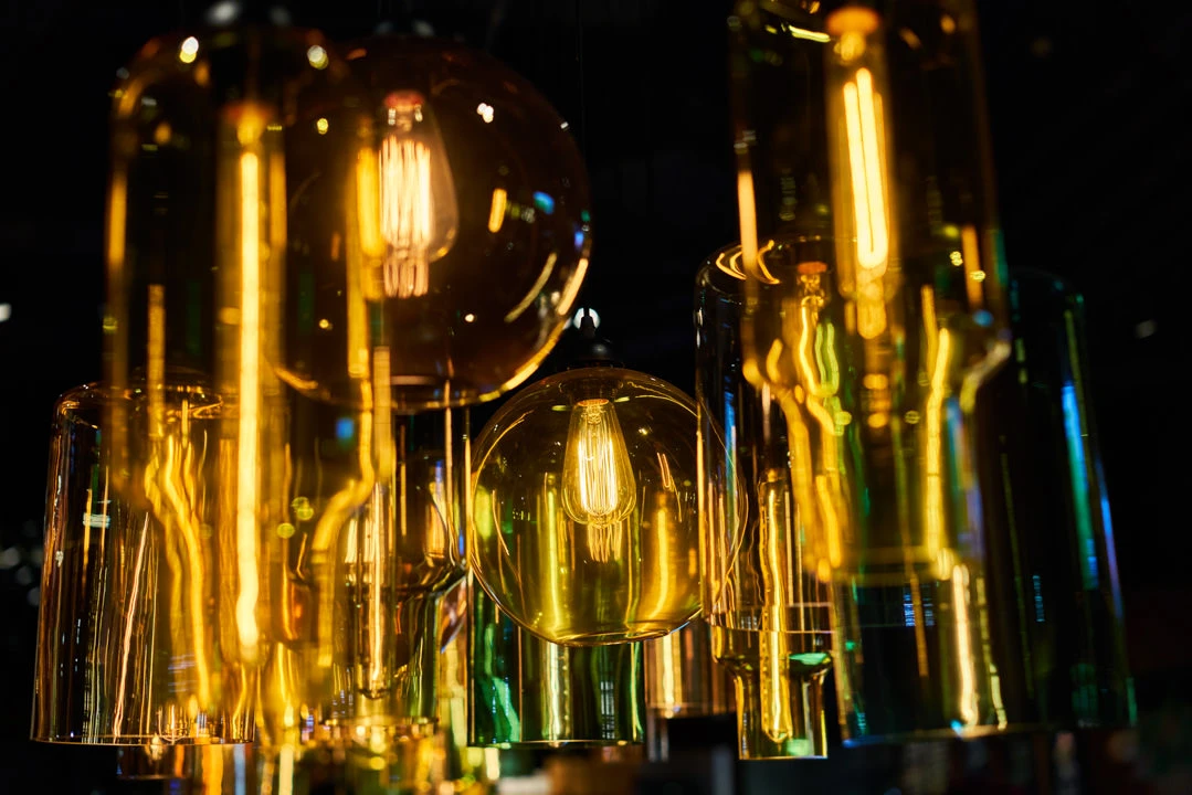 Glass pendant macro with golden and emerald filament reflections — Crowne Plaza Beijing Lido restaurant photography