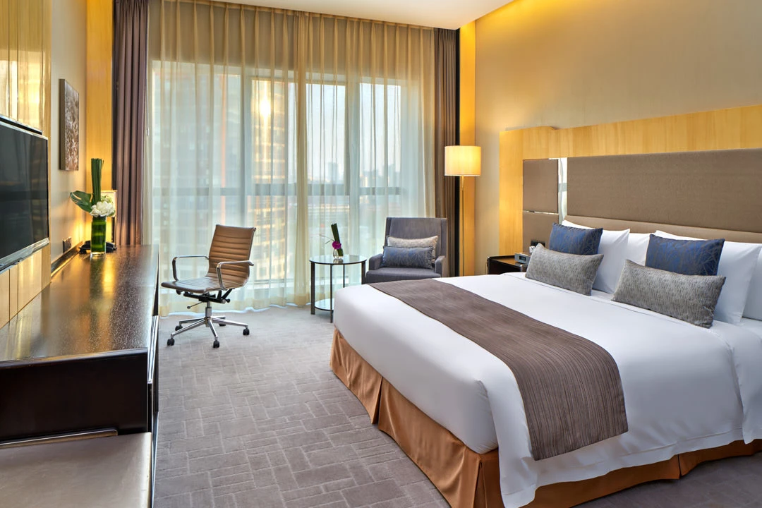 Deluxe king room with cove headboard lighting and leather desk chair — Crowne Plaza Beijing Lido hotel photography