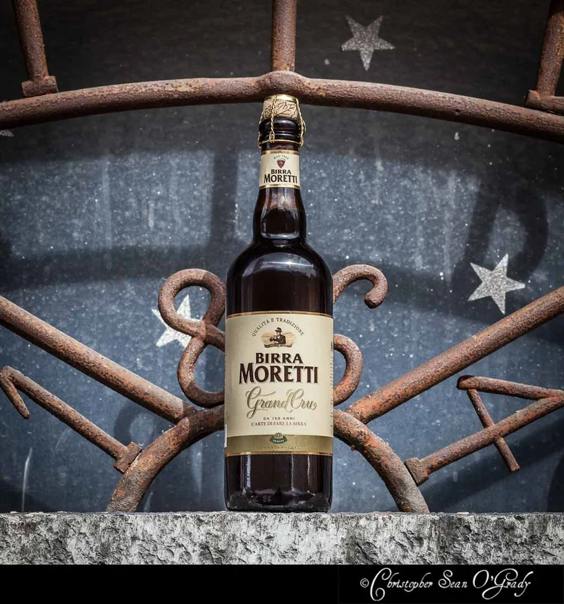 Birra Moretti Grand Cru at an ornate rusty iron gate with star details