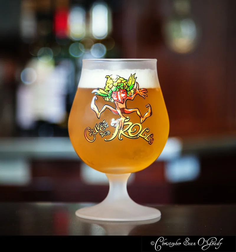 Cuvee des Trolls Belgian ale in branded tulip glass on a dark bar counter
