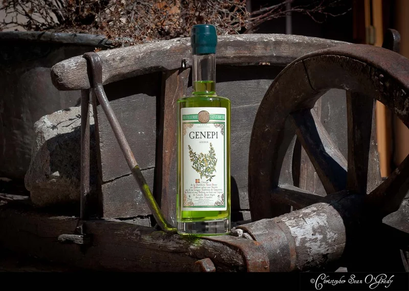 Genepi liqueur by Distillerie Saint-Bruno on a rustic wooden cart wheel
