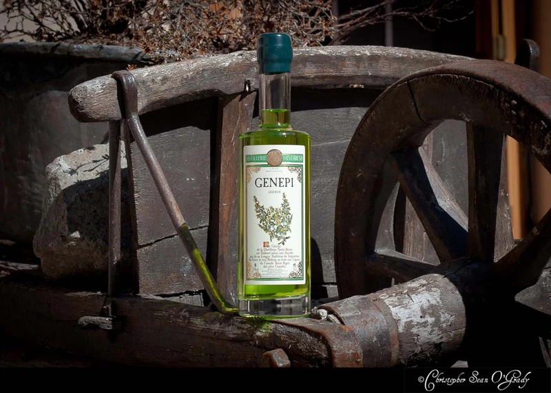 Genepi liqueur by Distillerie Saint-Bruno on a rustic wooden cart wheel