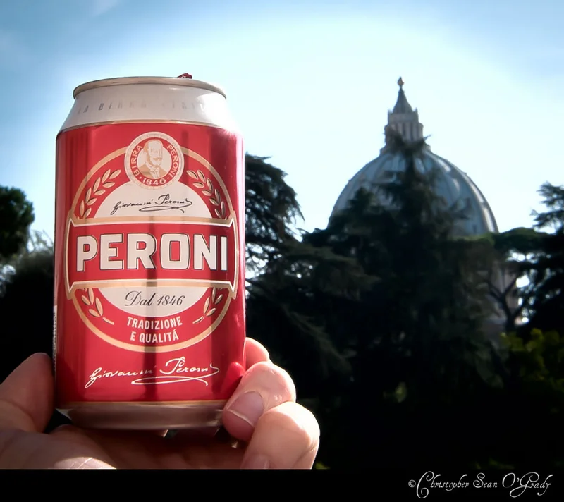 Peroni beer can held up with St Peter's Basilica dome in Rome