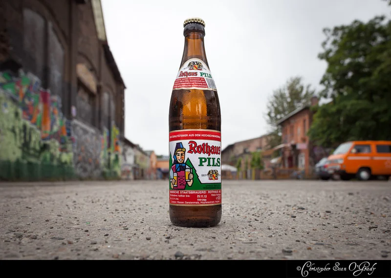 Rothaus Pils beer bottle on a graffiti-lined urban street in Germany