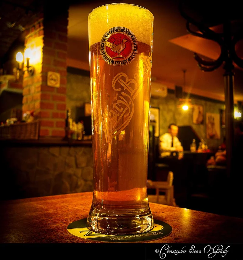 Zlaty Bazant Slovak beer in a tall glass at a warmly lit pub