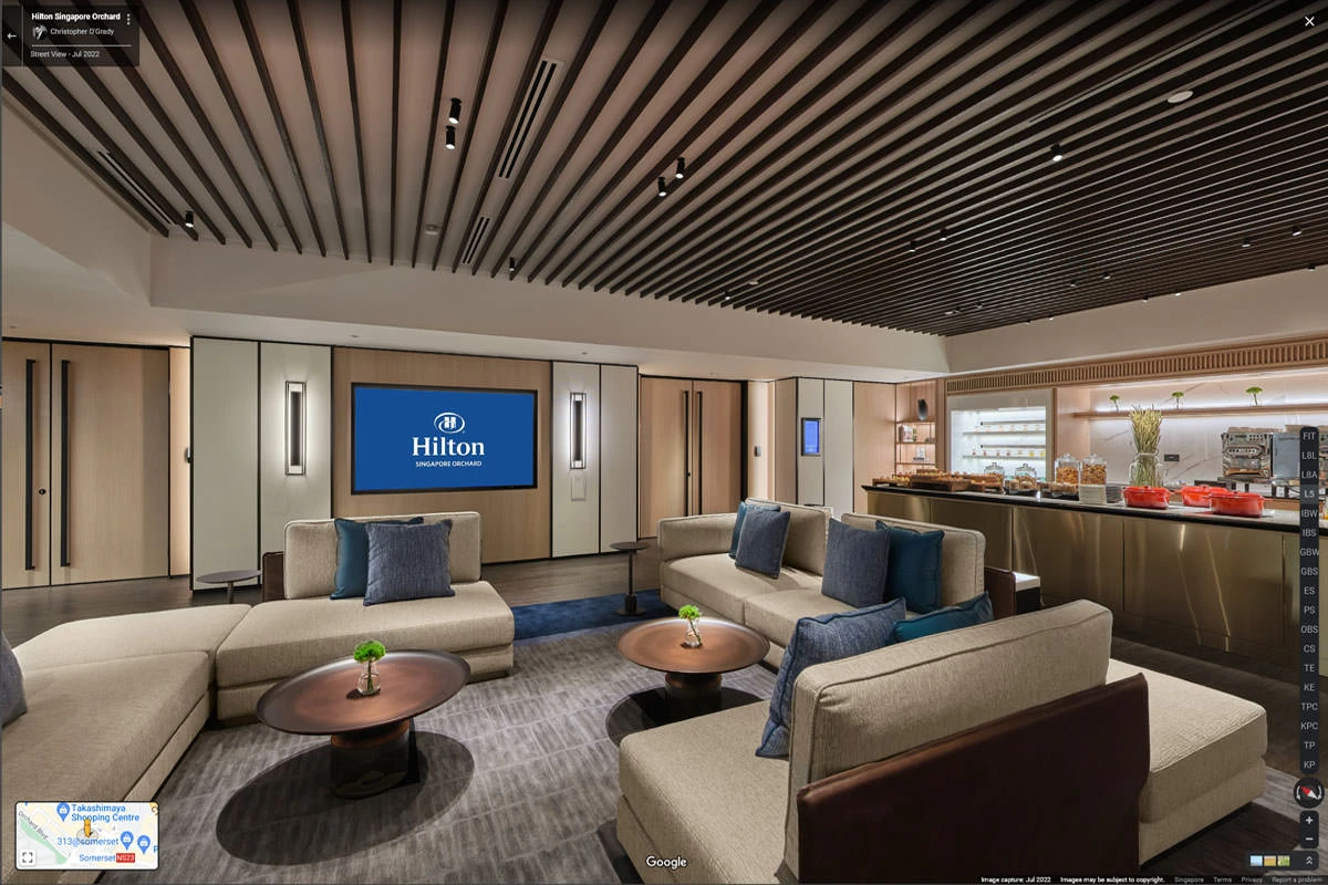 Executive lounge with sofas, buffet station, and branded screen at Hilton Singapore Orchard hotel virtual tour