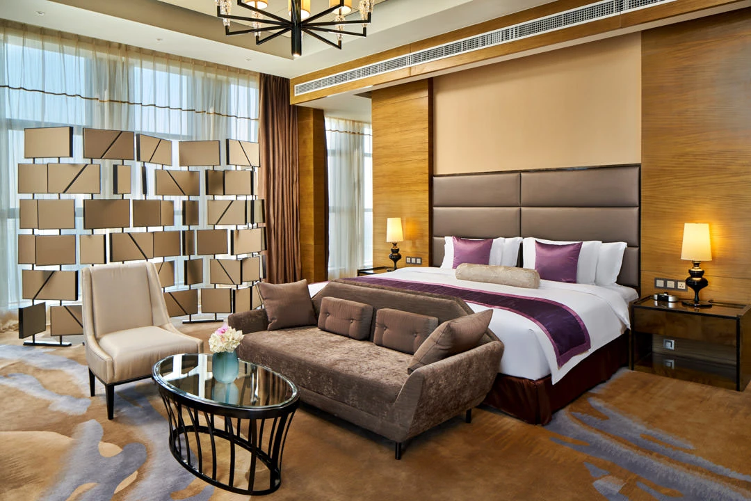 Suite bedroom with grey headboard, purple accents and mirrored divider — Crowne Plaza Tianjin Meijiangnan hotel photography