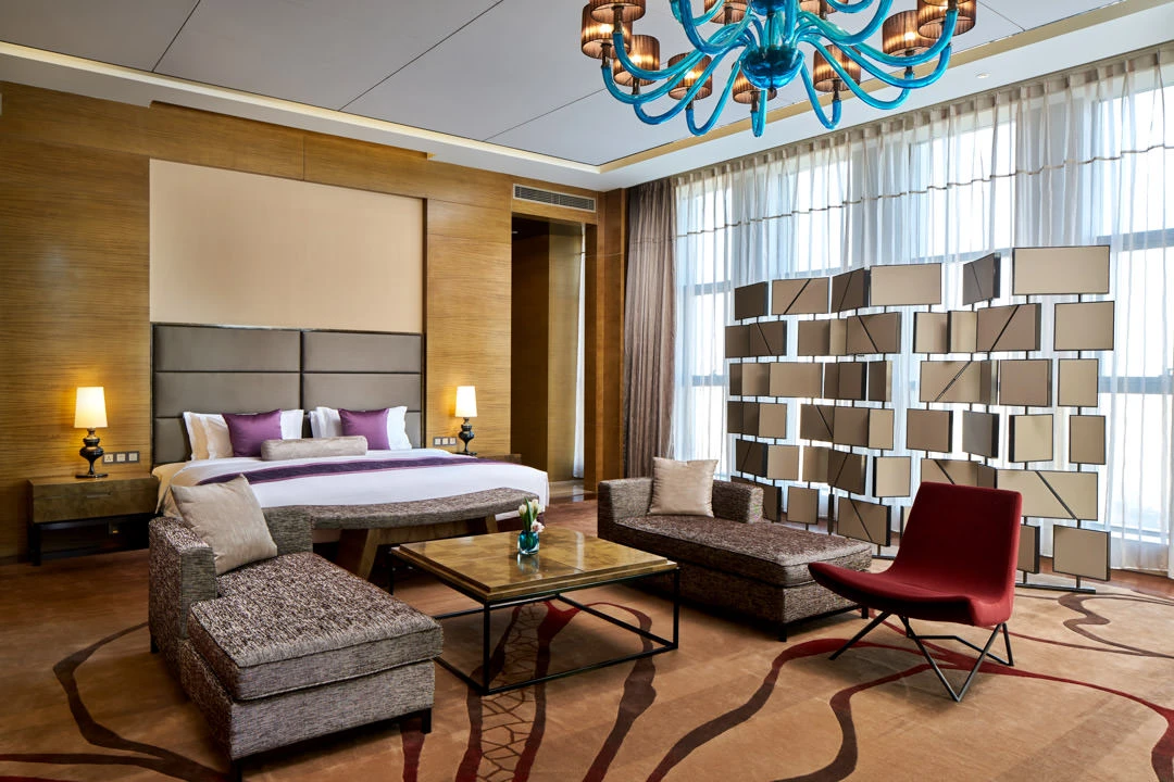 Presidential suite with turquoise Murano chandelier and red accent chair — Crowne Plaza Tianjin Meijiangnan hospitality photography